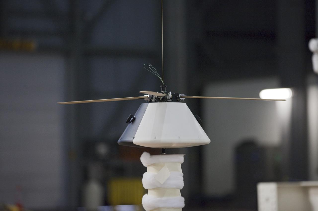 CAPE CANAVERAL, Fla. - A model capsule following a test inside the Vehicle Assembly Building at NASA's Kennedy Space Center in Florida to test a rotor system landing design. The design would give a capsule the stability and control of a helicopter, but would not be powered. Instead, the wind passing over the rotors as the capsule descends would make the blades turn, a process called auto-rotation. The intent is to give real spacecraft a soft landing with enough control that they could touch down anywhere in the world, whether it be a runway or parking lot. In other words, wherever a helicopter could land, a spacecraft could land, too. Photo credit: NASA/Kim Shiflett