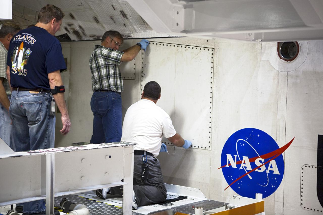 CAPE CANAVERAL, Fla. – Inside Orbiter Processing Facility-2 at NASA’s Kennedy Space Center in Florida, United Space Alliance technicians close space shuttle Atlantis’ midbody door for the final time. The orbiter is undergoing final preparations for its transfer to the Kennedy Space Center Visitor complex targeted for November. The work is part of Transition and Retirement of the remaining shuttle. Atlantis is being prepared for public display at the visitor complex. Over the course of its 26-year career, Atlantis spent 293 days in space during 33 missions. For more information, visit http://www.nasa.gov/transition. Photo credit: NASA/Dimitri Gerondidakis