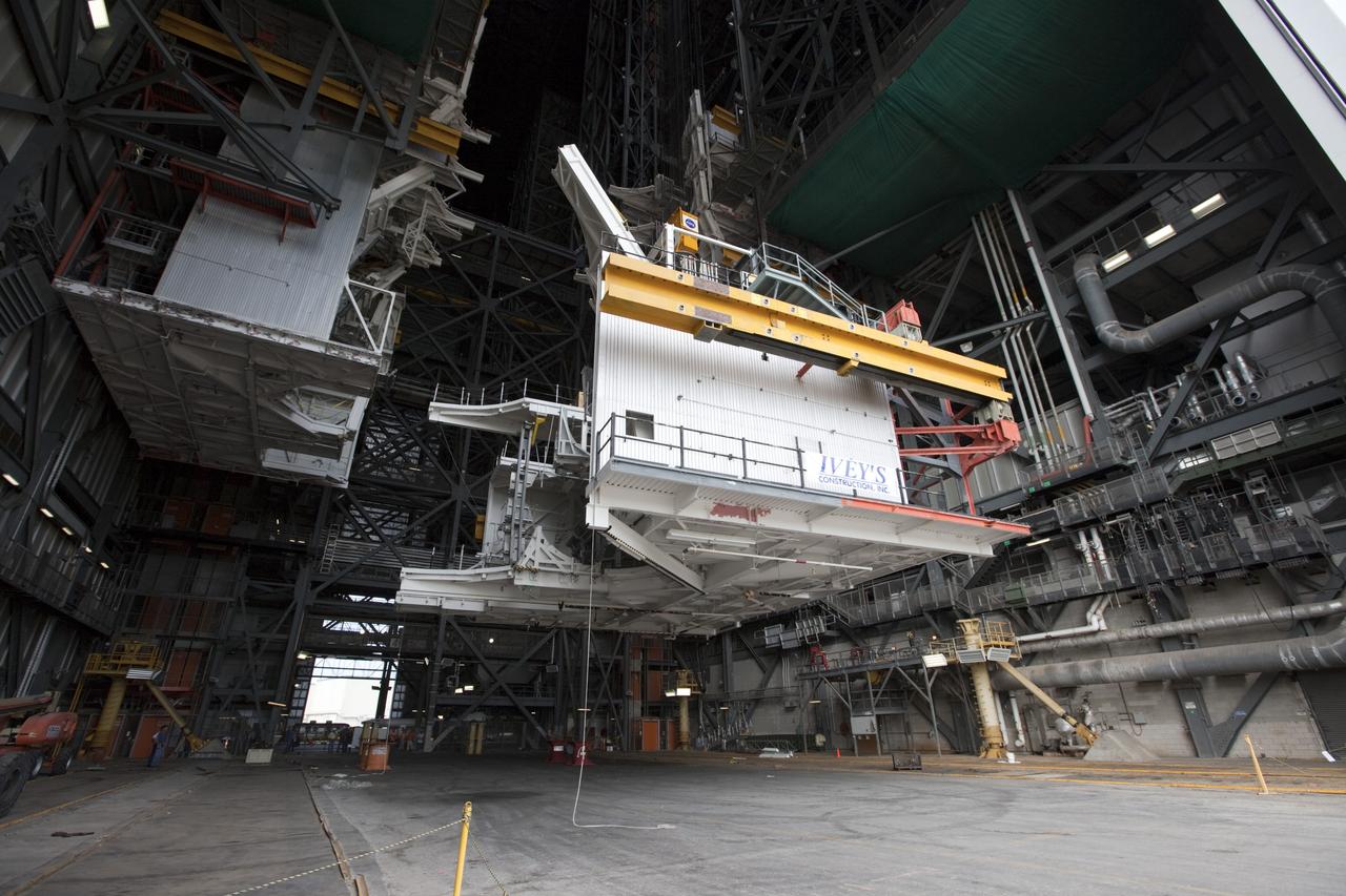 CAPE CANAVERAL, Fla. -- At NASA’s Kennedy Space Center in Florida, construction workers lower the large space shuttle-era Level E north work platform from high bay 3 inside the Vehicle Assembly Building, or VAB. The platform will be moved to the VAB north parking area for temporary storage.    The work is part of a center-wide refurbishment initiative under the Ground Systems Development and Operations, or GSDO, Program. High bay 3 is being refurbished to accommodate NASA’s Space Launch System and a variety of other spacecraft.  For more information, visit http://www.nasa.gov/exploration/systems/ground/index.html. Photo credit: NASA/Kim Shiflett