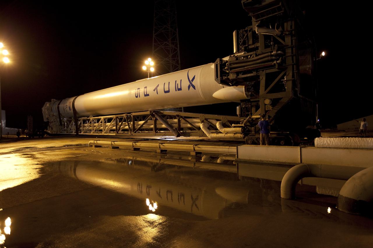 CAPE CANAVERAL, Fla. -- A Falcon 9 rocket with a Dragon capsule secured atop is reflected in the rainwater standing on the surface of Space Launch Complex 40 on Cape Canaveral Air Force Station in Florida as it rolls from the processing hangar to the pad.      Space Exploration Technologies Corp., or SpaceX, built both the rocket and capsule for NASA's first Commercial Resupply Services, or CRS-1, mission to the International Space Station.  Rollout was complete at 9:55 p.m. EDT.  SpaceX CRS-1 is an important step toward making America’s microgravity research program self-sufficient by providing a way to deliver and return significant amounts of cargo, including science experiments, to and from the orbiting laboratory. Launch is scheduled for 8:35 p.m. EDT on Oct. 7. NASA has contracted for 12 commercial resupply flights from SpaceX and eight from the Orbital Sciences Corp. For more information, visit http://www.nasa.gov/mission_pages/station/living/launch/index.html.  Photo credit: NASA/Kim Shiflett