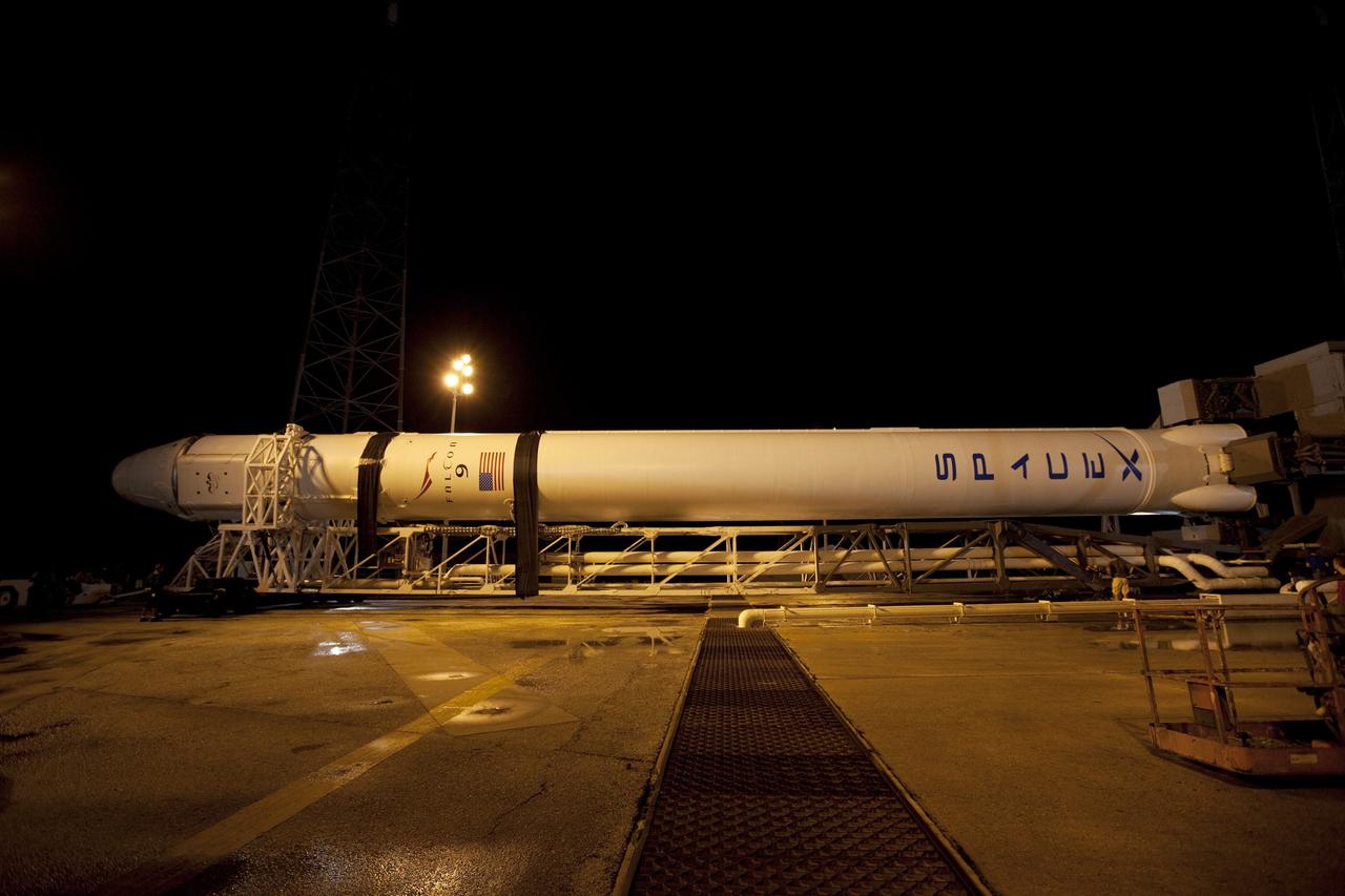 CAPE CANAVERAL, Fla. -- A Falcon 9 rocket with a Dragon capsule secured atop rolls into position between the lightning masts on the pad at Space Launch Complex 40 on Cape Canaveral Air Force Station in Florida. Preparations are under way to lift the rocket into a vertical position for launch.      Space Exploration Technologies Corp., or SpaceX, built both the rocket and capsule for NASA's first Commercial Resupply Services, or CRS-1, mission to the International Space Station.  Rollout was complete at 9:55 p.m. EDT.  SpaceX CRS-1 is an important step toward making America’s microgravity research program self-sufficient by providing a way to deliver and return significant amounts of cargo, including science experiments, to and from the orbiting laboratory. Launch is scheduled for 8:35 p.m. EDT on Oct. 7. NASA has contracted for 12 commercial resupply flights from SpaceX and eight from the Orbital Sciences Corp. For more information, visit http://www.nasa.gov/mission_pages/station/living/launch/index.html.  Photo credit: NASA/Kim Shiflett