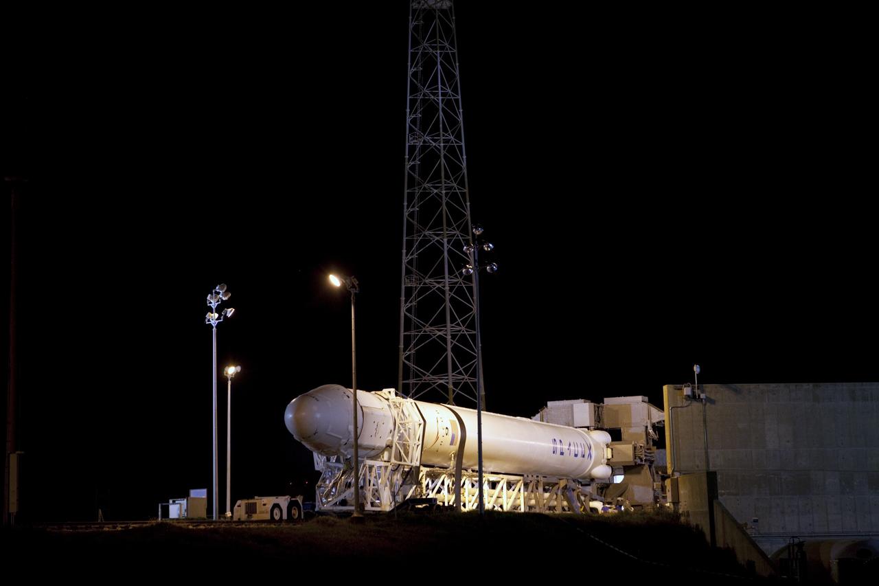 CAPE CANAVERAL, Fla. -- A Falcon 9 rocket with a Dragon capsule secured atop rolls into position between the lightning masts on the pad at Space Launch Complex 40 on Cape Canaveral Air Force Station in Florida. Preparations are under way to lift the rocket into a vertical position for launch.      Space Exploration Technologies Corp., or SpaceX, built both the rocket and capsule for NASA's first Commercial Resupply Services, or CRS-1, mission to the International Space Station.  Rollout was complete at 9:55 p.m. EDT.  SpaceX CRS-1 is an important step toward making America’s microgravity research program self-sufficient by providing a way to deliver and return significant amounts of cargo, including science experiments, to and from the orbiting laboratory. Launch is scheduled for 8:35 p.m. EDT on Oct. 7. NASA has contracted for 12 commercial resupply flights from SpaceX and eight from the Orbital Sciences Corp. For more information, visit http://www.nasa.gov/mission_pages/station/living/launch/index.html.  Photo credit: NASA/Kim Shiflett