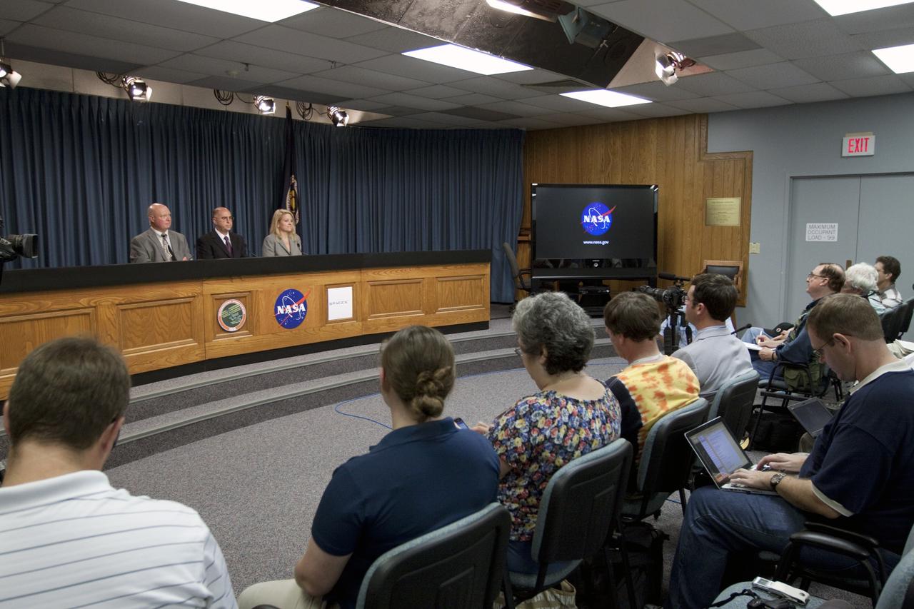 CAPE CANAVERAL, Fla. -- News and social media representatives participate in a post-launch news conference in the Press Site auditorium at NASA's Kennedy Space Center in Florida following the successful launch of NASA's first Commercial Resupply Services, or CRS-1, mission to the International Space Station. On the dais are, from left, Michael Curie, NASA Public Affairs, Sam Scimemi, director of International Space Station at NASA Headquarters, and Gwynne Shotwell, president of Space Exploration Technologies Corp., or SpaceX.     SpaceX built both the Falcon 9 rocket and Dragon capsule that launched at 8:35 p.m. EDT from Space Launch Complex 40 on Cape Canaveral Air Force Station. SpaceX CRS-1 is an important step toward making America’s microgravity research program self-sufficient by providing a way to deliver and return significant amounts of cargo, including science experiments, to and from the orbiting laboratory. NASA has contracted for 12 commercial resupply flights from SpaceX and eight from the Orbital Sciences Corp. For more information, visit http://www.nasa.gov/mission_pages/station/living/launch/index.html. Photo credit: NASA/Kim Shiflett