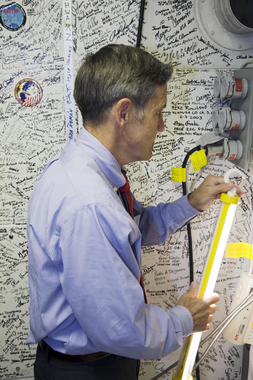 CAPE CANAVERAL, Fla. - After exiting space shuttle Atlantis inside Orbiter Processing Facility-2 at NASA’s Kennedy Space Center in Florida, Center Director Bob Cabana watches as United Space Alliance technicians prepare to close and seal Atlantis’ crew hatch for the final time.    The orbiter is undergoing final preparations for its transfer to the Kennedy Space Center Visitor complex targeted for Nov. 2. The work is part of Transition and Retirement of the remaining shuttle. Atlantis is being prepared for public display at the visitor complex. Over the course of its 26-year career, Atlantis spent 293 days in space during 33 missions. For more information, visit http://www.nasa.gov/transition. Photo credit: NASA/Frankie Martin