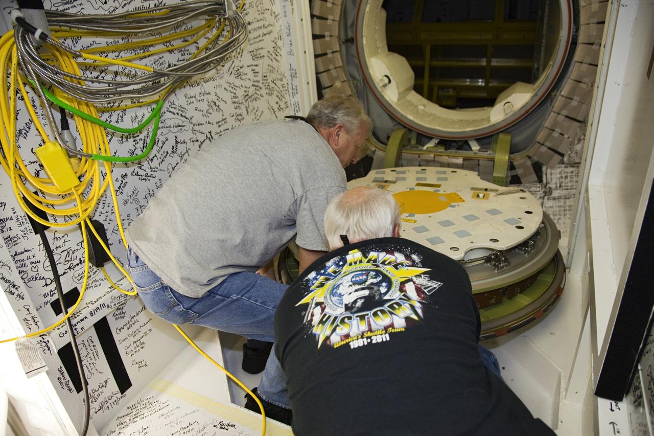 CAPE CANAVERAL, Fla. - Inside Orbiter Processing Facility-2 at NASA’s Kennedy Space Center in Florida, United Space Alliance technicians Danny Brown, at left, and Dave Chodkowski prepare to close space shuttle Atlantis’ crew hatch for the final time.    The orbiter is undergoing final preparations for its transfer to the Kennedy Space Center Visitor complex targeted for Nov. 2. The work is part of Transition and Retirement of the remaining shuttle. Atlantis is being prepared for public display at the visitor complex. Over the course of its 26-year career, Atlantis spent 293 days in space during 33 missions. For more information, visit http://www.nasa.gov/transition. Photo credit: NASA/Frankie Martin