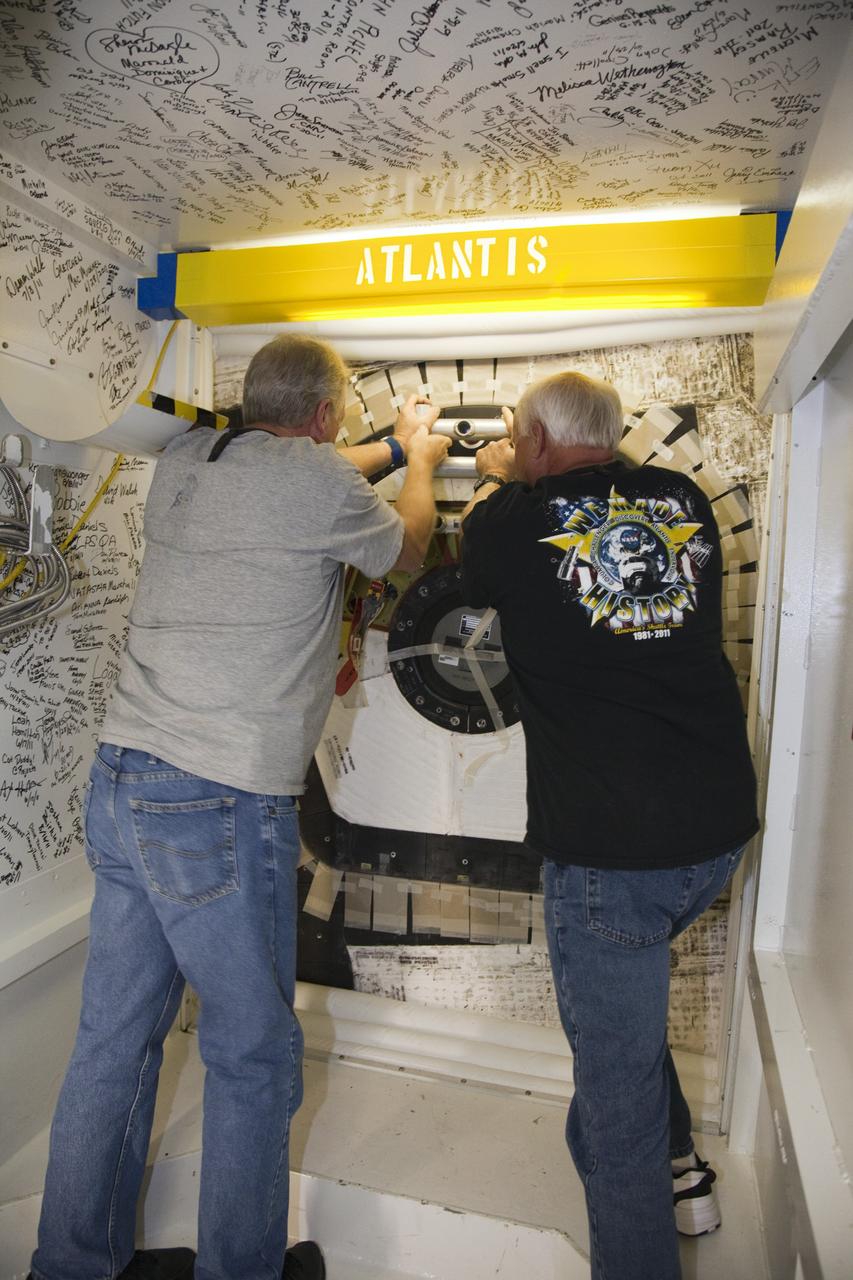 CAPE CANAVERAL, Fla. - Inside Orbiter Processing Facility-2 at NASA’s Kennedy Space Center in Florida, United Space Alliance technicians Danny Brown, at left, and Dave Chodkowski close space shuttle Atlantis’ crew hatch for the final time.    The orbiter is undergoing final preparations for its transfer to the Kennedy Space Center Visitor complex targeted for Nov. 2. The work is part of Transition and Retirement of the remaining shuttle. Atlantis is being prepared for public display at the visitor complex. Over the course of its 26-year career, Atlantis spent 293 days in space during 33 missions. For more information, visit http://www.nasa.gov/transition. Photo credit: NASA/Frankie Martin