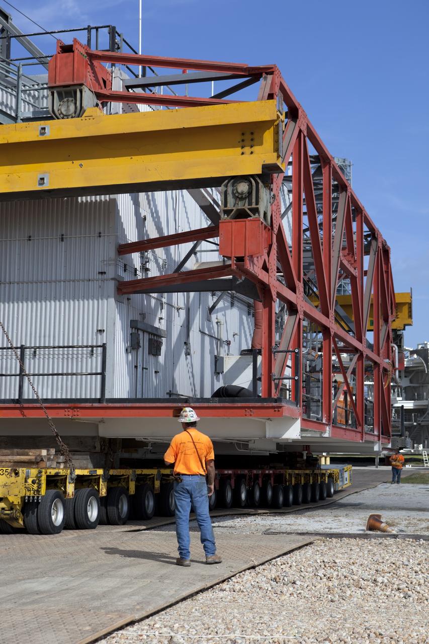 CAPE CANAVERAL, Fla. – As part of NASA's Ground Systems Development and Operations Program at the Kennedy Space Center in Florida, a technician oversees a large space shuttle-era work platform being removed by transporter from high bay 3 of the Vehicle Assembly Building, or VAB. The work is part of a center-wide modernization and refurbishment initiative to accommodate NASA’s Space Launch System and a variety of other spacecraft instead of the whole building supporting one design. The Ground Systems Development and Operations Program is developing the necessary ground systems, infrastructure and operational approaches required to safely process, assemble, transport and launch the next generation of rockets and spacecraft in support of NASA’s exploration objectives. Future work also will replace the antiquated communications, power and vehicle access resources with modern efficient systems. Some of the utilities and systems slated for replacement have been used since the VAB opened in 1965. For more information, visit http://www.nasa.gov/exploration/systems/ground/index.html Photo credit: NASA/Dimitri Gerondidakis