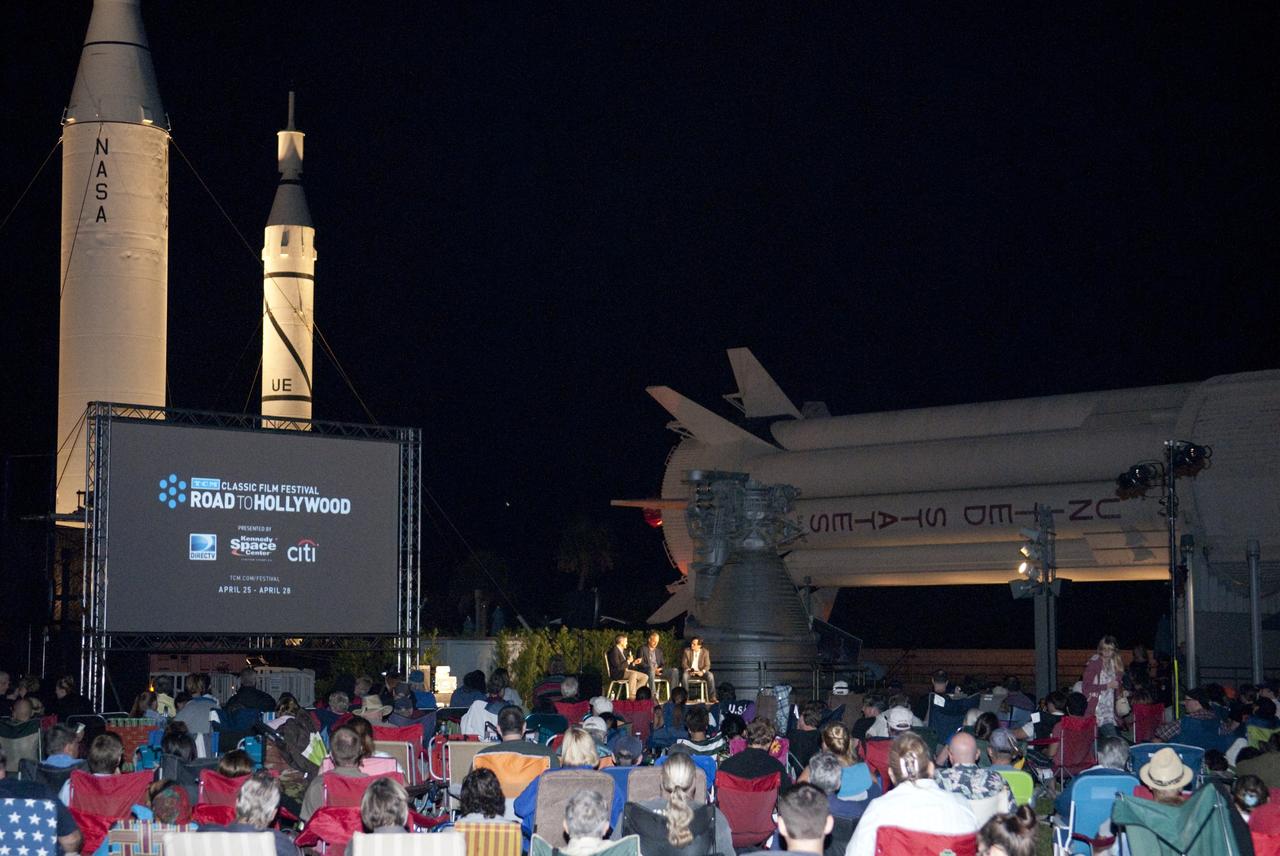 CAPE CANAVERAL, Fla. – The Rocket Garden at the Kennedy Space Center Visitor Complex in Florida provides an appropriate backfor a free screening of the film "Forbidden Planet" for NASA Kennedy Space Center employees, their families and members of the general public. The film is hosted by Turner Classic Movies, or TCM, as part of their Classic Film Festival. Participating in a panel discussion before the movie begins are, from left, Kennedy Director Robert Cabana, NASA astronaut Mike Massimino and TCM host Ben Mankiewicz.    "Forbidden Planet," starring Walter Pigeon, Anne Francis and Leslie Nielsen, was nominated for an Academy Award in 1956 for best special effects in part for its robot character, Robby. Its storyline follows astronauts sent to a planet to find out why there has been no communication from the scientists working there. For more information about the Rocket Garden and the Kennedy Space Center Visitor Complex, visit http://www.kennedyspacecenter.com.  Photo credit: NASA/Tim Jacobs