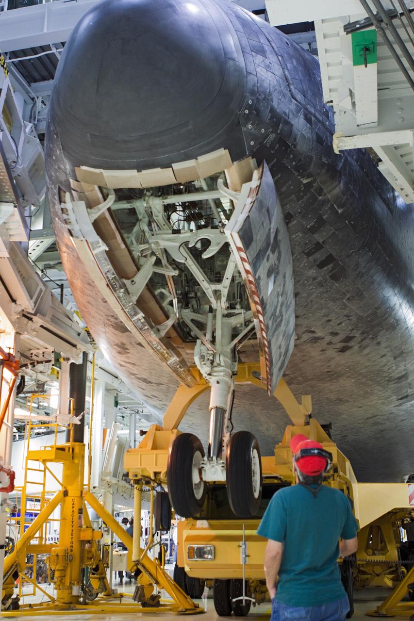 CAPE CANAVERAL, Fla. – A technician surveys the nose gear as space shuttle Atlantis is loaded onto the orbiter transporter vehicle in Orbiter Processing Facility-2 at NASA's Kennedy Space Center in Florida. The shuttle is being prepared for its move from the OPF to the Vehicle Assembly Building during transition and retirement work. Later, the shuttle will be taken to the Kennedy Space Center Visitor Complex where it will go on public display. Photo credit: NASA/Jim Grossmann