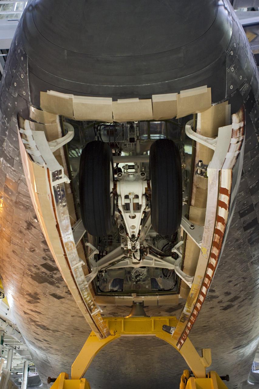 CAPE CANAVERAL, Fla. – The nose gear of space shuttle Atlantis retracts as the shuttle sits on the orbiter transporter vehicle in Orbiter Processing Facility-2 at NASA's Kennedy Space Center in Florida. The shuttle is being prepared for its move from the OPF to the Vehicle Assembly Building during transition and retirement work. Later, the shuttle will be taken to the Kennedy Space Center Visitor Complex where it will go on public display. Photo credit: NASA/Jim Grossmann