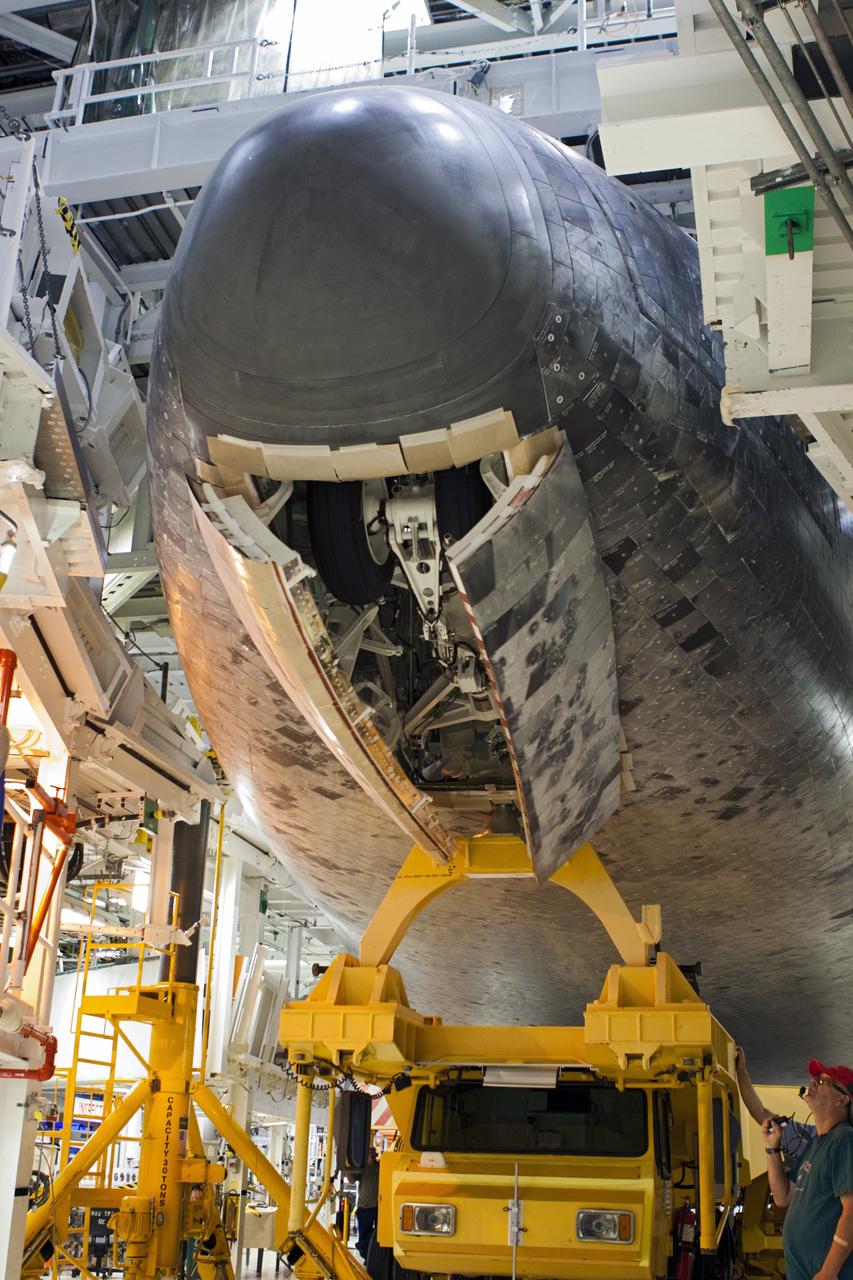 CAPE CANAVERAL, Fla. – The nose gear of space shuttle Atlantis retracts as the shuttle sits on the orbiter transporter vehicle in Orbiter Processing Facility-2 at NASA's Kennedy Space Center in Florida. The shuttle is being prepared for its move from the OPF to the Vehicle Assembly Building during transition and retirement work. Later, the shuttle will be taken to the Kennedy Space Center Visitor Complex where it will go on public display. Photo credit: NASA/Jim Grossmann