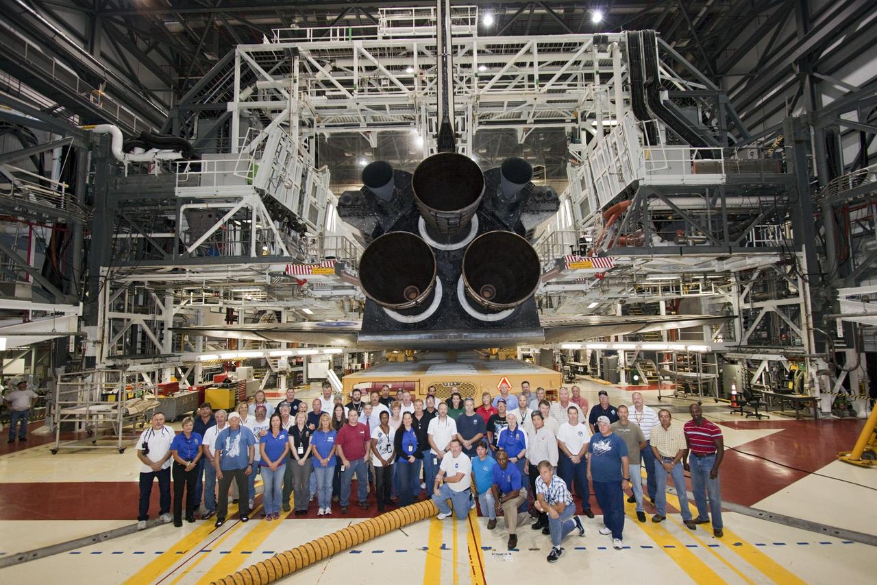 CAPE CANAVERAL, Fla. – Workers pose with space shuttle Atlantis as it is prepped for its move from Orbiter Processing Facility-2 to the Vehicle Assembly Building at NASA's Kennedy Space Center in Florida. Atlantis will be moved to the Kennedy Space Center Visitor Complex in November where it will be put on public display. Photo credit: NASA/Jim Grossmann