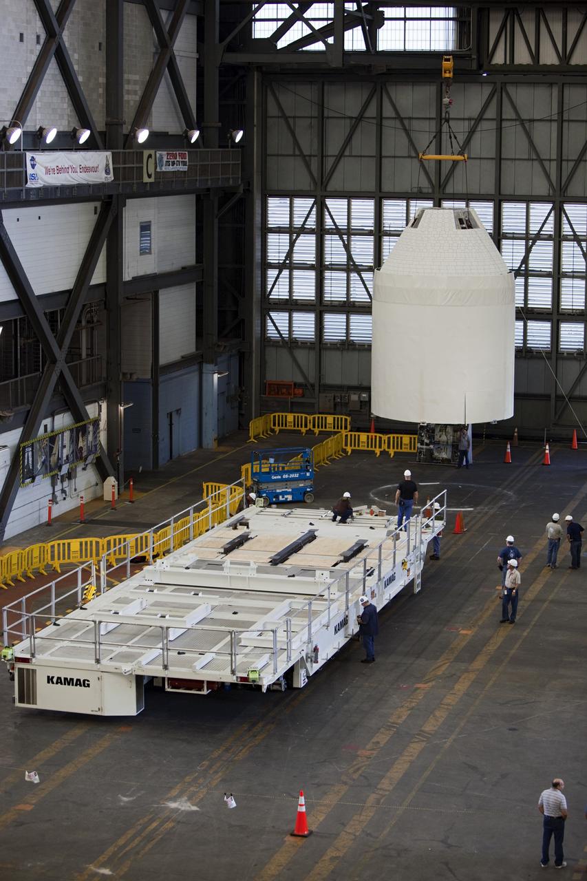 CAPE CANAVERAL, Fla. – An Orion mockup spacecraft atop its service module simulator is lifted in the transfer aisle of the Vehicle Assembly Building, or VAB, at NASA's Kennedy Space Center in Florida. The Orion mockup is exact in details on the outside, but mostly empty on the inside. The work in the VAB is crucial to making sure the designs are accurate. Orion is the exploration spacecraft designed to carry crews to space beyond low Earth orbit. It will provide emergency abort capability, sustain the crew during the space travel and provide safe re-entry from deep space return velocities. The first unpiloted test flight of the Orion is scheduled to launch in 2014 atop a Delta IV rocket and in 2017 on a Space Launch System rocket. For more information, visit http://www.nasa.gov/orion Photo credit: NASA/ Dmitri Gerondidakis