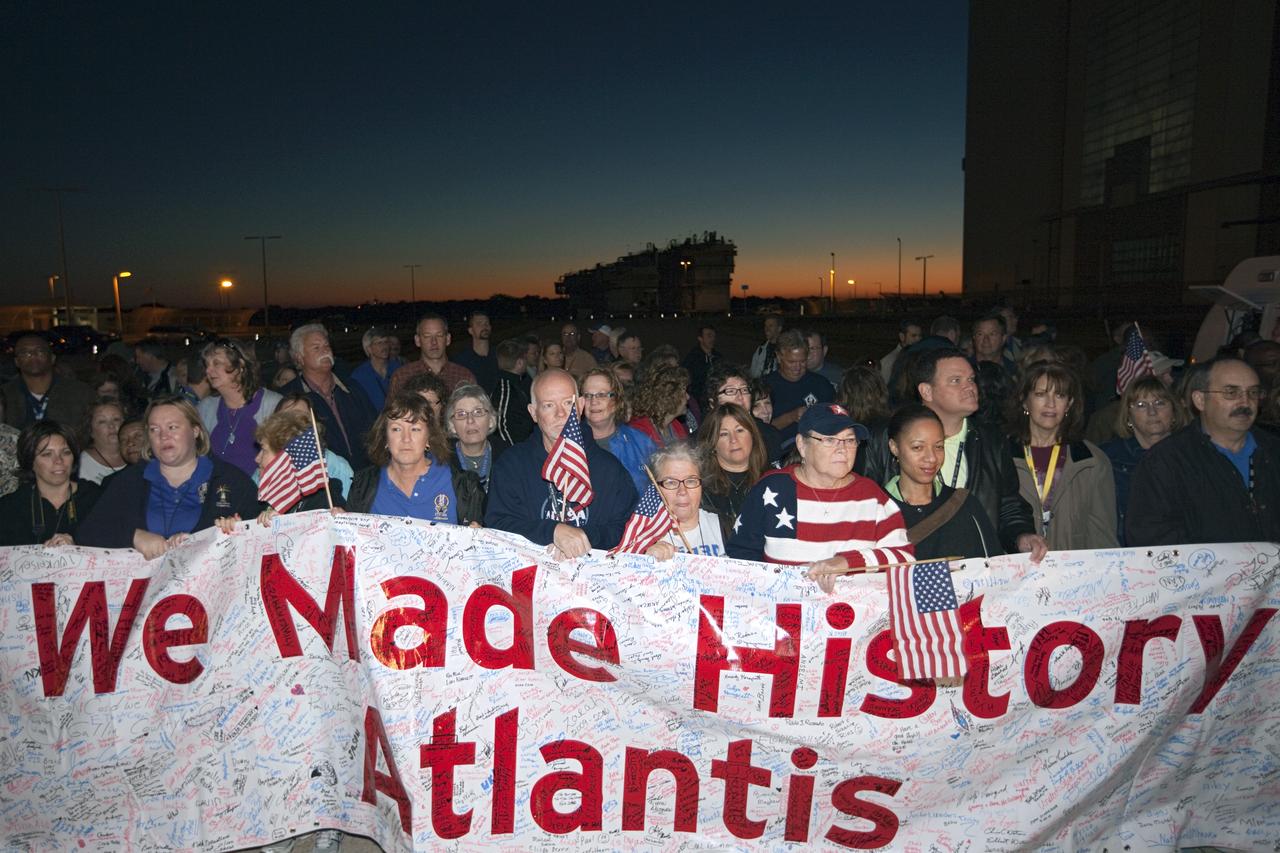 CAPE CANAVERAL, Fla. – Space shuttle team members carry a "We Made History Atlantis" banner as the spacecraft moves out of the Vehicle Assembly Building at NASA's Kennedy Space Center in Florida for its 10-mile trip to the Kennedy Visitor Complex where it will be put on public display. As part of transition and retirement of the Space Shuttle Program, Atlantis is to be displayed at Kennedy's Visitor Complex beginning in the summer of 2013. Over the course of its 26-year career, Atlantis traveled 125,935,769 miles during 307 days in space over 33 missions. For more information, visit http://www.nasa.gov/transition Photo credit: NASA/ Kim Shiflett