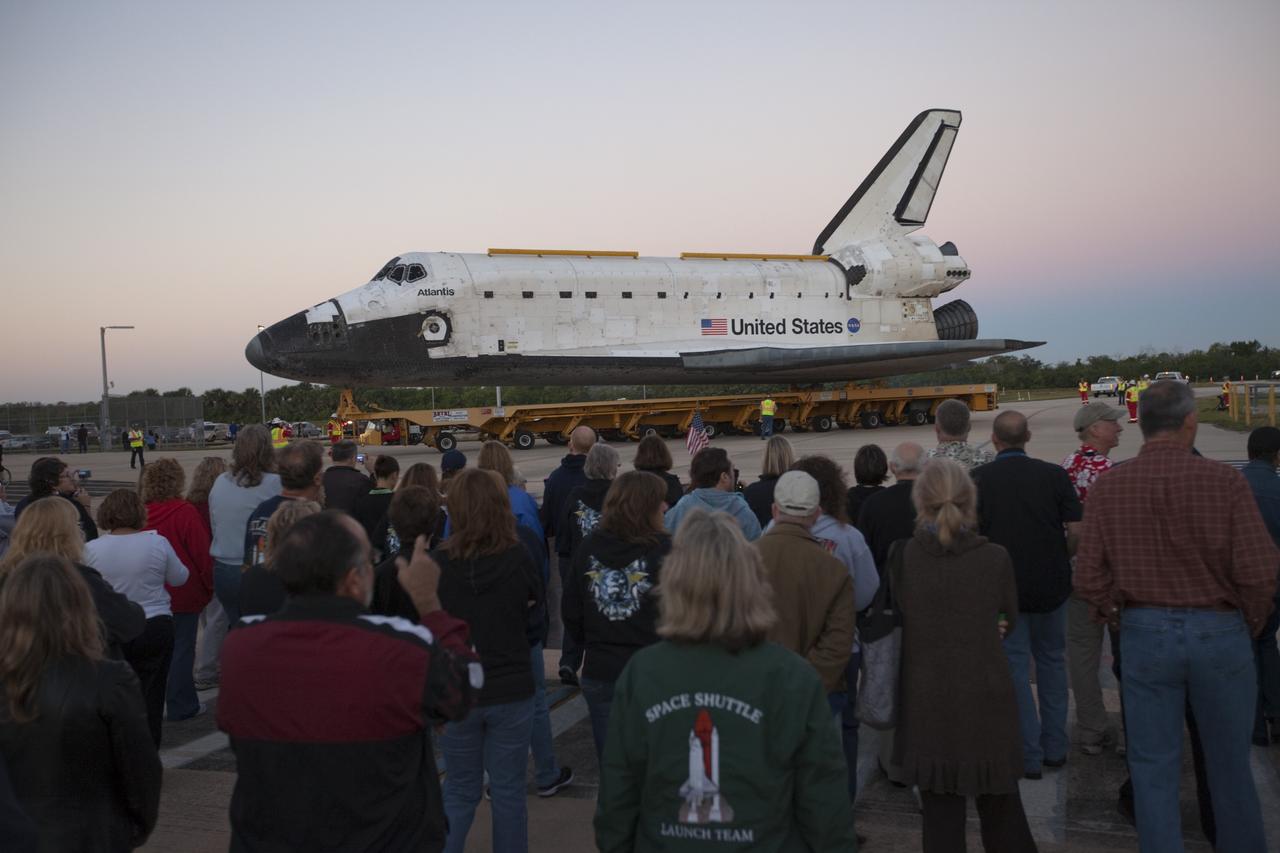 CAPE CANAVERAL, Fla. – Space shuttle workers at NASA's Kennedy Space Center in Florida, watch as the space shuttle Atlantis is transported on a 10-mile journey to the Kennedy Visitor Complex where it will be put on public display. As part of transition and retirement of the Space Shuttle Program, Atlantis is to be displayed at Kennedy's Visitor Complex beginning in the summer of 2013. Over the course of its 26-year career, Atlantis traveled 125,935,769 miles during 307 days in space over 33 missions. For more information, visit http://www.nasa.gov/transition Photo credit: NASA/ Kim Shiflett