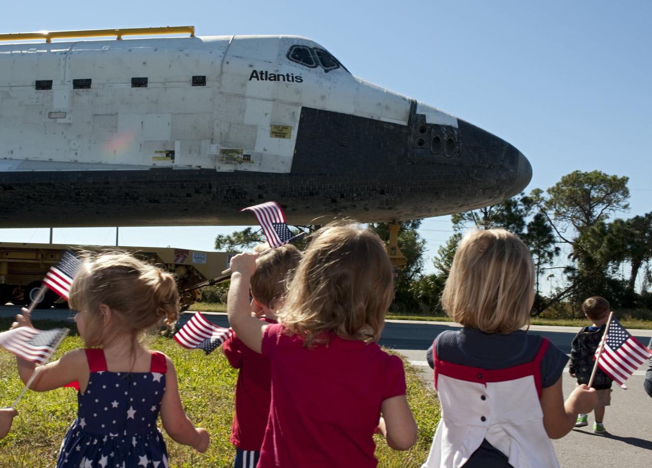 CAPE CANAVERAL, Fla. – Flag waving children welcome the space shuttle Atlantis as it approaches Space Florida's Exploration Park. Atlantis will pause during its 10-mile journey to the Kennedy Space Center Visitor Complex providing a viewing opportunity for guests before completing the trip to its new home. As part of transition and retirement of the Space Shuttle Program, Atlantis is to be displayed at Kennedy's Visitor Complex beginning in the summer of 2013. Over the course of its 26-year career, Atlantis traveled 125,935,769 miles during 307 days in space over 33 missions. For more information, visit http://www.nasa.gov/transition Photo credit: NASA/ Tony Gray