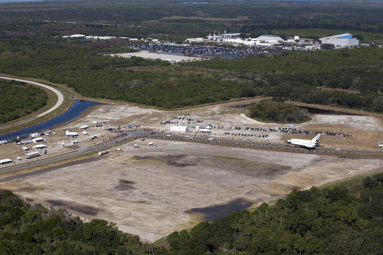 CAPE CANAVERAL, Fla. – At NASA's Kennedy Space Center in Florida, space shuttle Atlantis approaches Space Florida's Exploration Park during its 10-mile journey from the Vehicle Assembly Building to the Kennedy Space Center Visitor Complex. Atlantis will stop in the park for a viewing opportunity for visitor complex guests before completing the trip to its new home.     As part of transition and retirement of the Space Shuttle Program, Atlantis will be displayed in a new exhibit hall at the visitor complex beginning in the summer of 2013. Over the course of its 26-year career, Atlantis traveled 125,935,769 miles, completing 33 missions during 307 days in space. For more information, visit http://www.nasa.gov/transition.  Photo credit: NASA/Kim Shiflett