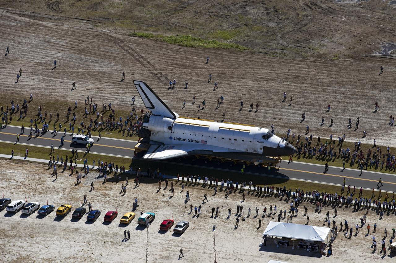 CAPE CANAVERAL, Fla. – At NASA's Kennedy Space Center in Florida, a crowd forms around space shuttle Atlantis as it travels through Space Florida's Exploration Park during its 10-mile journey from the Vehicle Assembly Building to the Kennedy Space Center Visitor Complex. Atlantis will stop in the park for a viewing opportunity for visitor complex guests before completing the trip to its new home. As part of transition and retirement of the Space Shuttle Program, Atlantis will be displayed in a new exhibit hall at the visitor complex beginning in the summer of 2013. Over the course of its 26-year career, Atlantis traveled 125,935,769 miles, completing 33 missions during 307 days in space. For more information, visit http://www.nasa.gov/transition. Photo credit: NASA/Kim Shiflett