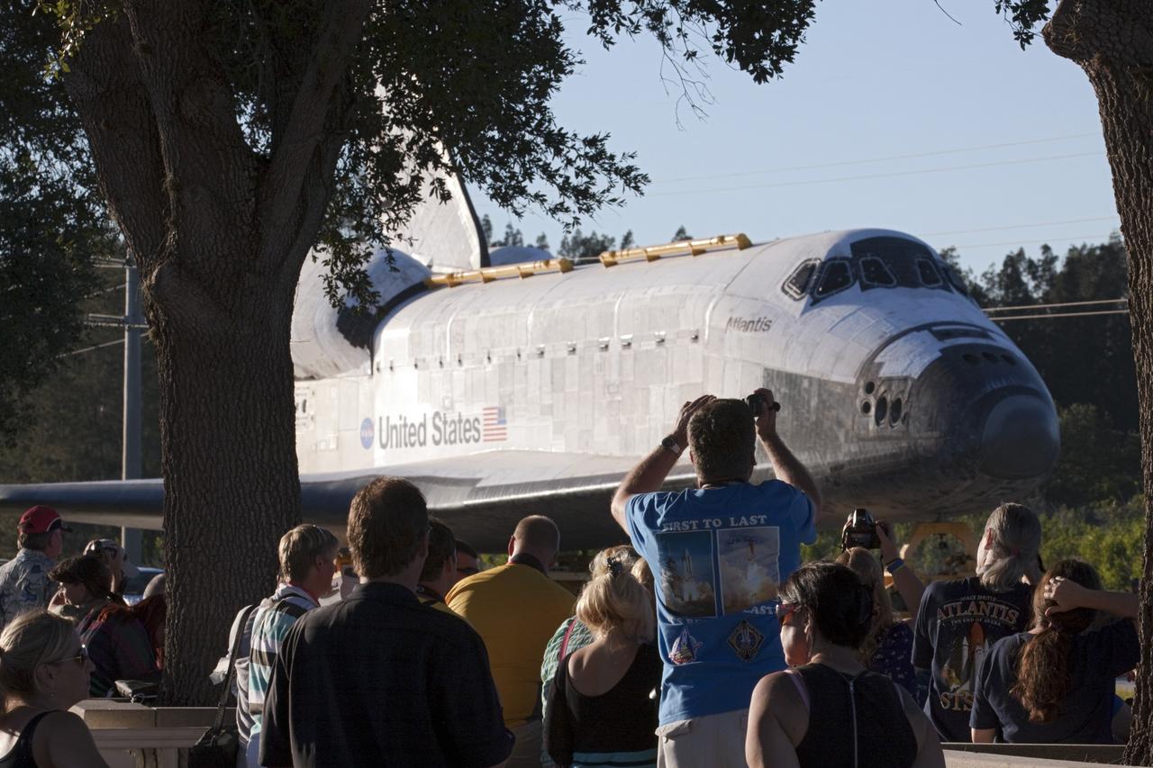 CAPE CANAVERAL, Fla. – Space shuttle Atlantis appears to smile for the camera as it passes a crowd gathered near the Kennedy Space Center Visitor Complex in Florida. Atlantis is traveling down the NASA Causeway, nearing the end of its 10-mile journey from Kennedy's Vehicle Assembly Building to its new home. As part of transition and retirement of the Space Shuttle Program, Atlantis will be displayed in a new exhibit hall at Kennedy's visitor complex beginning in the summer of 2013. Over the course of its 26-year career, Atlantis traveled 125,935,769 miles, completing 33 missions during 307 days in space. For more information, visit http://www.nasa.gov/transition. Photo credit: NASA/Kim Shiflett