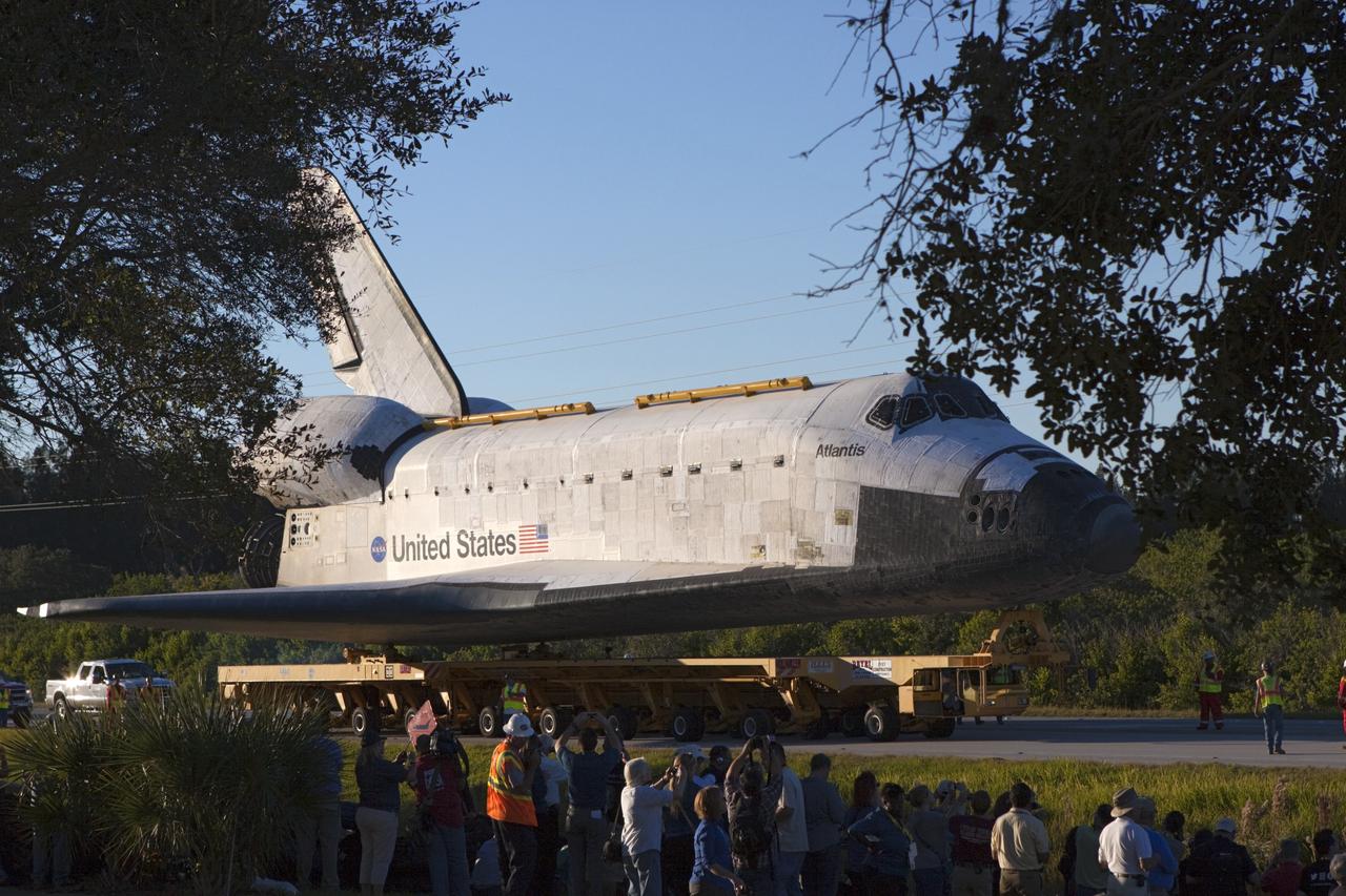 CAPE CANAVERAL, Fla. – Kennedy Space Center workers and members of the media watch as space shuttle Atlantis is transported along the NASA Causeway on its 10-mile journey from NASA Kennedy Space Center’s Vehicle Assembly Building in Florida to the Kennedy Visitor Complex where it will be put on public display. As part of transition and retirement of the Space Shuttle Program, Atlantis will be displayed at Kennedy’s Visitor Complex beginning in the summer of 2013. Over the course of its 26-year career, Atlantis traveled 125,935,769 miles during 307 days in space over 33 missions. For more information, visit http://www.nasa.gov/transition. Photo credit: NASA/Jim Grossmann