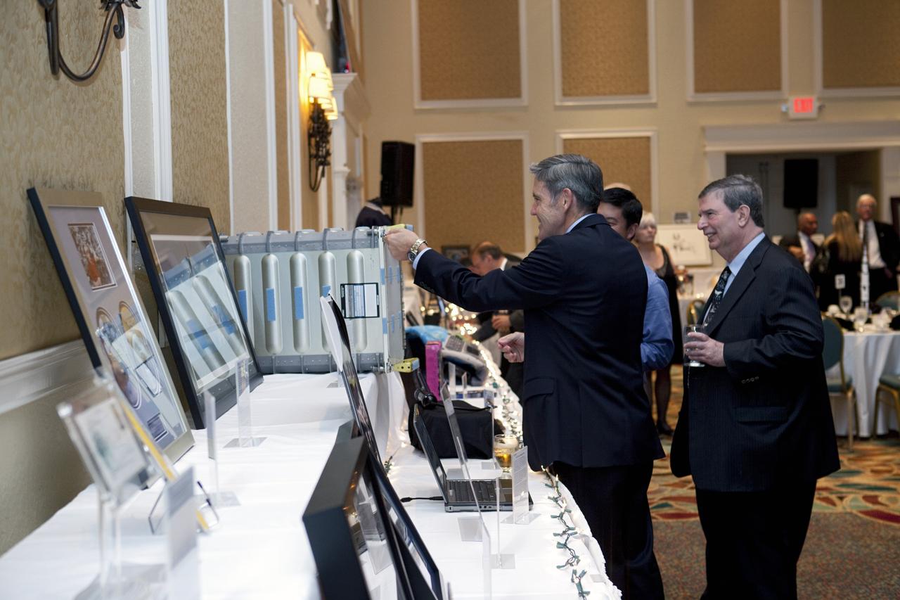 CAPE CANAVERAL, Fla. – Kennedy Space Center Director Bob Cabana checks out an item available for auction at the Astronaut Scholarship Foundation's dinner at the Radisson Resort at the Port in Cape Canaveral celebrating the 40th anniversary of Apollo 17. The auction of space-related memorabilia was held with proceeds supporting college scholarships for students who exhibit imagination and exceptional performance in science, technology, engineering and math.  The gala commemorating the anniversary of Apollo 17 included mission commander Eugene Cernan and other astronauts who flew Apollo missions. Launched Dec. 7, 1972, Cernan and lunar module pilot Harrison Schmitt landed in the moon's Taurus-Littrow highlands while command module pilot Ronald Evans remained in lunar orbit operating a scientific instrument module. For more information, visit http://www-pao.ksc.nasa.gov/history/apollo/apollo-17/apollo-17.htm Photo credit: NASA/Kim Shiflett