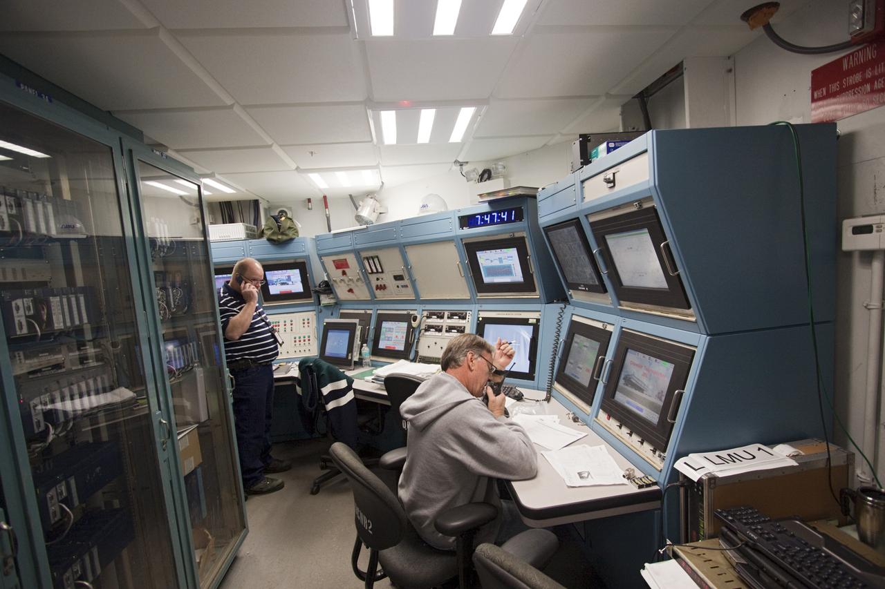 CAPE CANAVERAL, Fla. -- Bill Couch, standing on the left, and Gary Milbourne, both of United Space Alliance monitor the updated controls of crawler-transporter No. 2 as it moves out of high bay 2 of the Vehicle Assembly Building at NASA's Kennedy Space Center in Florida. The test drive is designed to check out recent modifications and upgrades to ensure its capability to carry launch vehicles such as the space agency's Space Launch System heavy-lift rocket to the launch pad. NASA's Ground Systems Development and Operations Program is leading the 20-year life-extension project for the crawler. A pair of behemoth machines called crawler-transporters has carried the load of taking rockets and spacecraft to the launch pad for more than 40 years at NASA’s Kennedy Space Center in Florida. Each the size of a baseball infield and powered by locomotive and large electrical power generator engines, the crawler-transporters will stand ready to keep up the work for the next generation of launch vehicles projects to lift astronauts into space. For more information, visit http://www.nasa.gov/exploration/systems/ground/index.html Photo credit: NASA/Jim Grossmann