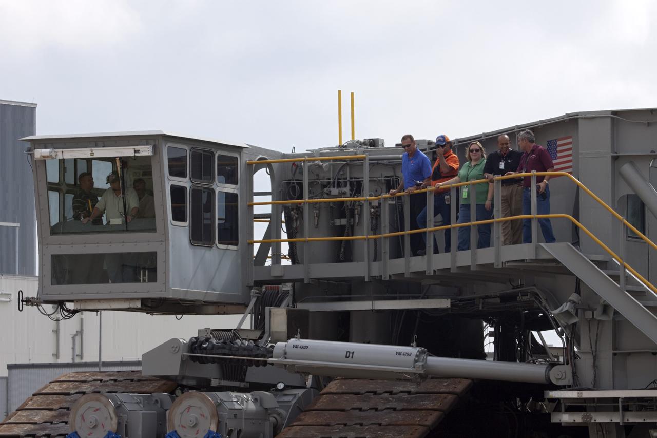 CAPE CANAVERAL, Fla. -- As crawler-transporter No. 2 moves out of high bay 2 of the Vehicle Assembly Building at NASA's Kennedy Space Center in Florida, technicians keep watch. The crawler-transporter test drive is designed to check out recent modifications to ensure its ability to carry launch vehicles such as the space agency's Space Launch System heavy-lift rocket to the launch pad. NASA's Ground Systems Development and Operations Program is leading the 20-year life-extension project for the crawler. A pair of behemoth machines called crawler-transporters has carried the load of taking rockets and spacecraft to the launch pad for more than 40 years at NASA’s Kennedy Space Center in Florida. Each the size of a baseball infield and powered by locomotive and large electrical power generator engines, the crawler-transporters will stand ready to keep up the work for the next generation of launch vehicles projects to lift astronauts into space. For more information, visit http://www.nasa.gov/exploration/systems/ground/index.html Photo credit: NASA/Jim Grossmann