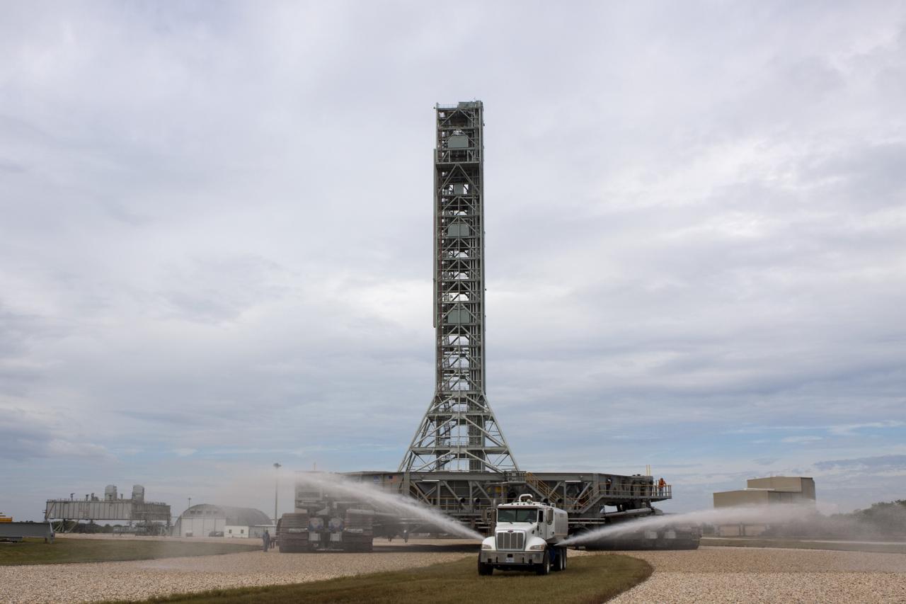 CAPE CANAVERAL, Fla. -- A truck sprays water on the gravel crawler way at NASA's Kennedy Space Center in Florida as crawler-transporter No. 2 moves toward Launch Pad 39A. With crawler-transporter modifications complete, the test drive is designed to check out modifications to ensure its ability to carry launch vehicles such as the space agency's Space Launch System heavy-lift rocket to the launch pad. NASA's Ground Systems Development and Operations Program is leading the 20-year life-extension project for the crawler. A pair of behemoth machines called crawler-transporters has carried the load of taking rockets and spacecraft to the launch pad for more than 40 years at NASA’s Kennedy Space Center in Florida. Each the size of a baseball infield and powered by locomotive and large electrical power generator engines, the crawler-transporters will stand ready to keep up the work for the next generation of launch vehicles projects to lift astronauts into space. For more information, visit http://www.nasa.gov/exploration/systems/ground/index.html Photo credit: NASA/Jim Grossmann