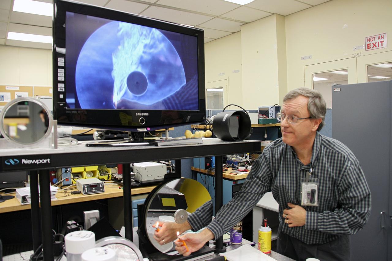 CAPE CANAVERAL, Fla. -- Inside the Applied Physics Laboratory in the Operations and Checkout Building at NASA’s Kennedy Space Center in Florida, lead researcher Dr. Bob Youngquist demonstrates a technology developed for the Space Shuttle Program to a group of Society of Physics students. About 800 graduate and undergraduate physics students toured Kennedy facilities. A group of about 40 students toured laboratories in the Operations and Checkout Building and the EDL during their visit. The physics students were in Orlando for the 2012 Quadrennial Physics Congress. Photo credit: NASA/Cory Huston