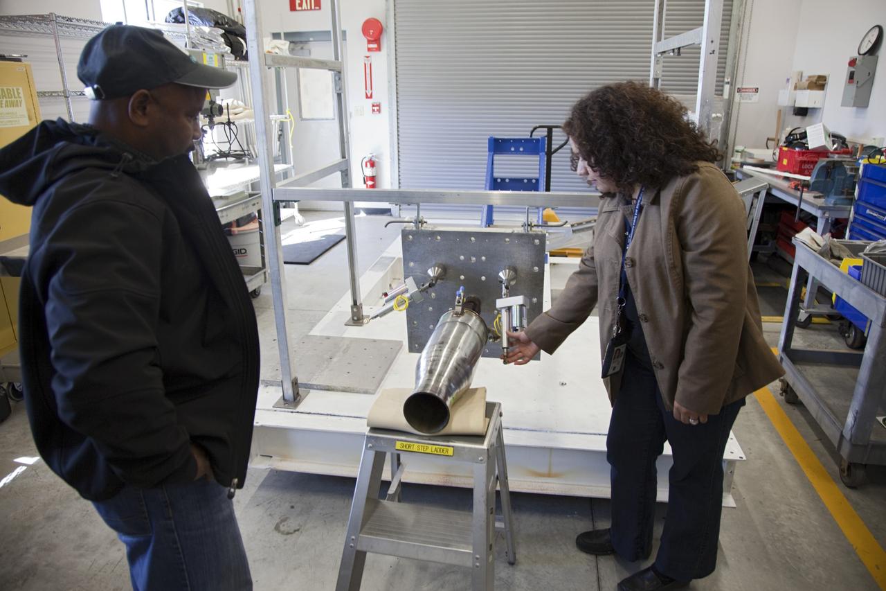 CAPE CANAVERAL, Fla. -- At the Neo Liquid Propellant Testbed inside a facility near Kennedy Space Center’s Shuttle Landing Facility in Florida, engineers and Rocket University project leads Kyle Dixon, left, and Evelyn Orozco-Smith check the buildup of the Neo test fixture and an Injector 71 engine that uses super-cooled propellants.    NASA engineers are working on the design and assembly of the Neo Liquid Propellant Testbed as part of the Engineering Directorate’s Rocket University training program. Photo credit: NASA/Frankie Martin