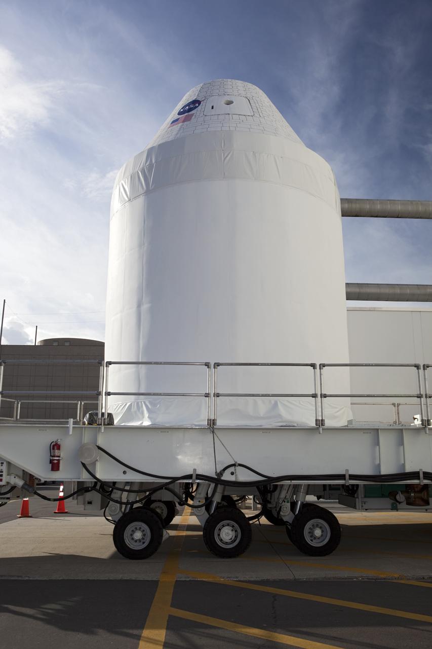 CAPE CANAVERAL, Fla. – A full-size test mock-up of the Orion spacecraft moves from the Operations and Checkout Building at NASA's Kennedy Space Center in Florida. The test article is on its way to the Multi-Payload Processing Facility, or MPPF, to test the path flight hardware will take during future launch processing. Orion is the exploration spacecraft designed to carry crews to space beyond low Earth orbit. It will provide emergency abort capability, sustain the crew during the space travel and provide safe re-entry from deep space return velocities. The first unpiloted test flight of the Orion is scheduled to launch in 2014 atop a Delta IV rocket and in 2017 on a Space Launch System rocket. For more information, visit http://www.nasa.gov/orion Photo credit: NASA/Dimitri Gerondidakis