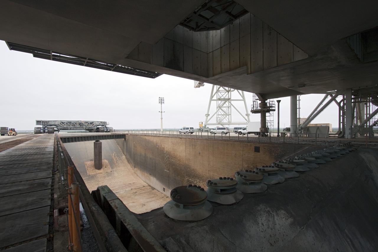 CAPE CANAVERAL, Fla. -- Viewed from under a space shuttle era mobile launcher platform on Launch Pad 39A at NASA's Kennedy Space Center in Florida, crawler-transporter No. 2 approaches. The activity was part of testing to check out recently completed modifications to ensure its ability to carry launch vehicles such as the space agency's Space Launch System heavy-lift rocket to the pad. NASA's Ground Systems Development and Operations Program is leading the 20-year life-extension project for the crawler. A pair of behemoth machines called crawler-transporters has carried the load of taking rockets and spacecraft to the launch pad for more than 40 years at NASA’s Kennedy Space Center in Florida. Each weighing six and a half million pounds and larger in size than a professional baseball infield, the crawler-transporters are powered by locomotive and large electrical power generator engines. The crawler-transporters will stand ready to keep up the work for the next generation of launch vehicles to lift astronauts into space. For more information, visit http://www.nasa.gov/exploration/systems/ground/index.html Photo credit: NASA/ Jim Grossmann