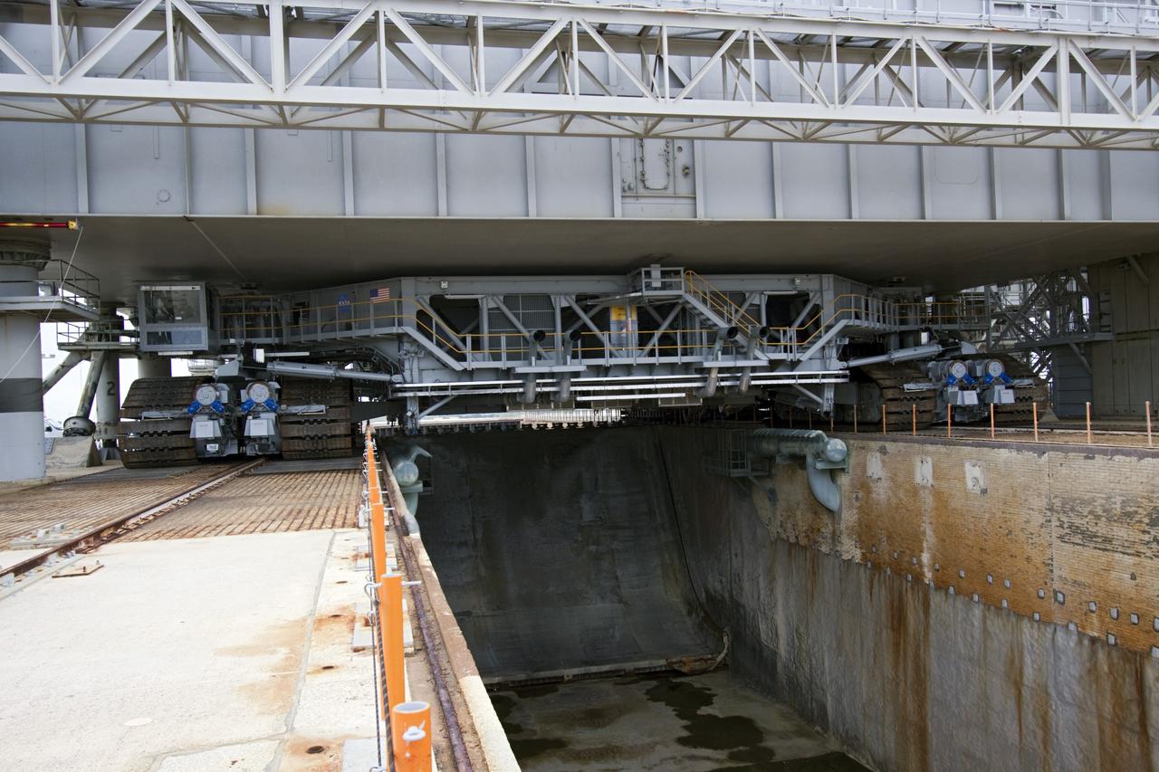 CAPE CANAVERAL, Fla. -- Viewed from under a space shuttle era mobile launcher platform on Launch Pad 39A at NASA's Kennedy Space Center in Florida, crawler-transporter No. 2 moves under. The activity was part of testing to check out recently completed modifications to ensure its ability to carry launch vehicles such as the space agency's Space Launch System heavy-lift rocket to the pad. NASA's Ground Systems Development and Operations Program is leading the 20-year life-extension project for the crawler. A pair of behemoth machines called crawler-transporters has carried the load of taking rockets and spacecraft to the launch pad for more than 40 years at NASA’s Kennedy Space Center in Florida. Each weighing six and a half million pounds and larger in size than a professional baseball infield, the crawler-transporters are powered by locomotive and large electrical power generator engines. The crawler-transporters will stand ready to keep up the work for the next generation of launch vehicles to lift astronauts into space. For more information, visit http://www.nasa.gov/exploration/systems/ground/index.html Photo credit: NASA/ Jim Grossmann