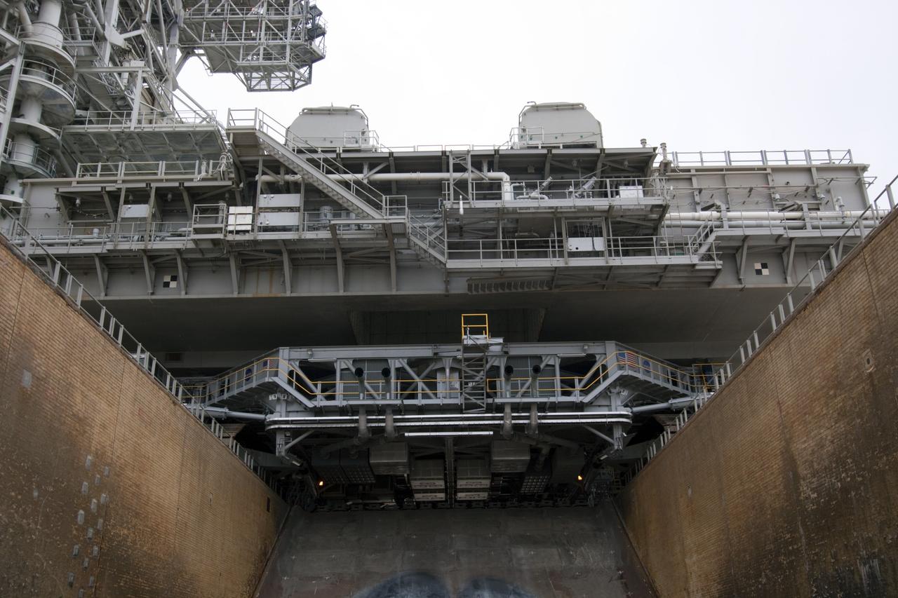 CAPE CANAVERAL, Fla. -- Viewed from the Launch Pad 39A flame trench, crawler-transporter No. 2 moves under a space shuttle era mobile launcher platform at NASA's Kennedy Space Center in Florida. The activity was part of testing to check out recently completed modifications to ensure its ability to carry launch vehicles such as the space agency's Space Launch System heavy-lift rocket to the pad. NASA's Ground Systems Development and Operations Program is leading the 20-year life-extension project for the crawler. A pair of behemoth machines called crawler-transporters has carried the load of taking rockets and spacecraft to the launch pad for more than 40 years at NASA’s Kennedy Space Center in Florida. Each weighing six and a half million pounds and larger in size than a professional baseball infield, the crawler-transporters are powered by locomotive and large electrical power generator engines. The crawler-transporters will stand ready to keep up the work for the next generation of launch vehicles to lift astronauts into space. For more information, visit http://www.nasa.gov/exploration/systems/ground/index.html Photo credit: NASA/ Jim Grossmann
