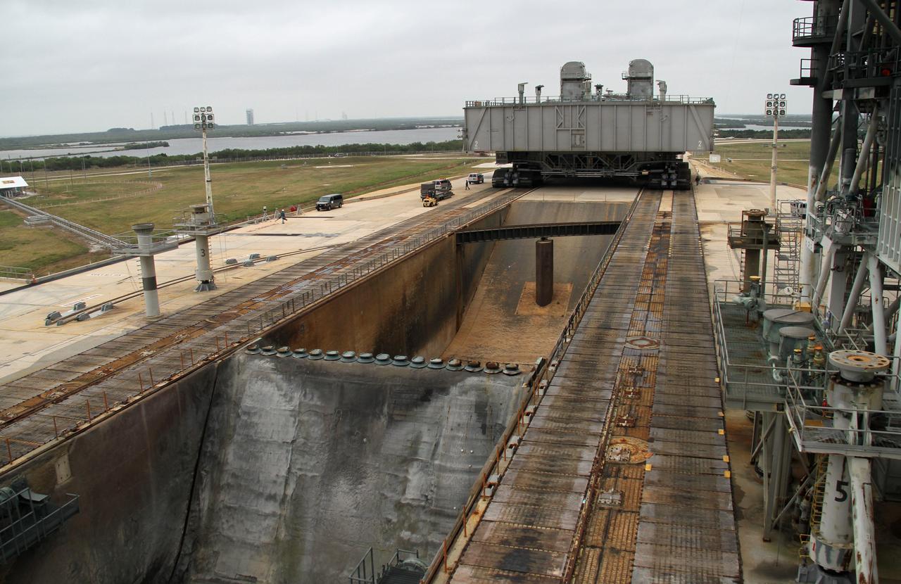 CAPE CANAVERAL, Fla. -- Viewed from above the flame trench at Launch Pad 39A at NASA's Kennedy Space Center in Florida, crawler-transporter No. 2 moves a space shuttle era mobile launcher platform. The activity was part of testing to check out recently completed modifications to ensure its ability to carry launch vehicles such as the space agency's Space Launch System heavy-lift rocket to the pad. NASA's Ground Systems Development and Operations Program is leading the 20-year life-extension project for the crawler. A pair of behemoth machines called crawler-transporters has carried the load of taking rockets and spacecraft to the launch pad for more than 40 years at NASA’s Kennedy Space Center in Florida. Each weighing six and a half million pounds and larger in size than a professional baseball infield, the crawler-transporters are powered by locomotive and large electrical power generator engines. The crawler-transporters will stand ready to keep up the work for the next generation of launch vehicles to lift astronauts into space. For more information, visit http://www.nasa.gov/exploration/systems/ground/index.html Photo credit: NASA/Cory Huston