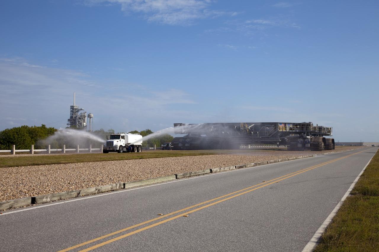 CAPE CANAVERAL, Fla. -- A truck sprays water on the gravel crawler way at NASA's Kennedy Space Center in Florida as crawler-transporter No. 2 completes testing at Launch Pad 39A. The activity is designed to check out recently completed modifications to ensure the crawler-transporter's ability to carry launch vehicles such as the space agency's Space Launch System heavy-lift rocket to the pad. NASA's Ground Systems Development and Operations Program is leading the 20-year life-extension project for the crawler. A pair of behemoth machines called crawler-transporters has carried the load of taking rockets and spacecraft to the launch pad for more than 40 years at NASA’s Kennedy Space Center in Florida. Each weighing six and a half million pounds and larger in size than a professional baseball infield, the crawler-transporters are powered by locomotive and large electrical power generator engines. The crawler-transporters will stand ready to keep up the work for the next generation of launch vehicles to lift astronauts into space. For more information, visit http://www.nasa.gov/exploration/systems/ground/index.html Photo credit: NASA/Frankie Martin