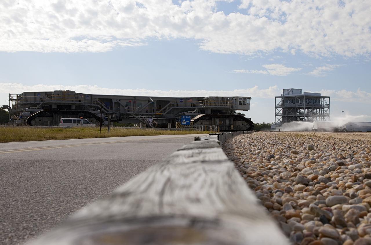 CAPE CANAVERAL, Fla. -- At NASA's Kennedy Space Center in Florida, crawler-transporter No. 2 moves along the gravel crawler way after completion of testing at Launch Pad 39A. The activity is designed to check out recently completed modifications to ensure the crawler-transporter's ability to carry launch vehicles such as the space agency's Space Launch System heavy-lift rocket to the pad. NASA's Ground Systems Development and Operations Program is leading the 20-year life-extension project for the crawler. A pair of behemoth machines called crawler-transporters has carried the load of taking rockets and spacecraft to the launch pad for more than 40 years at NASA’s Kennedy Space Center in Florida. Each weighing six and a half million pounds and larger in size than a professional baseball infield, the crawler-transporters are powered by locomotive and large electrical power generator engines. The crawler-transporters will stand ready to keep up the work for the next generation of launch vehicles to lift astronauts into space. For more information, visit http://www.nasa.gov/exploration/systems/ground/index.html Photo credit: NASA/Frankie Martin
