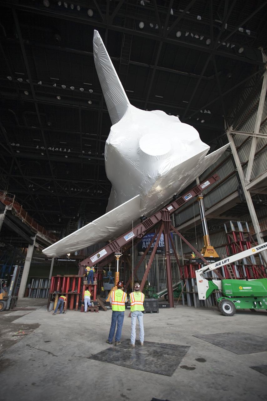 CAPE CANAVERAL, Fla. – The space shuttle Atlantis is lifted and tilted for display at the Kennedy Space Center Visitor Complex in Florida. Atlantis will be exhibited at 43.21 degrees with its payload bay doors open so the shuttle will look as it did in space. Atlantis was wrapped in a protective plastic to protect it from dust and debris while being prepared for display. The new home of Atlantis is scheduled to open in July 2013. The exhibits in the new, 90,000-square-foot interactive facility will tell the story of the 30-year Space Shuttle Program and what lies ahead in space exploration. More than 60 exhibits will be set up around Atlantis, including a full-scale mockup of the Hubble Space Telescope and a full-scale model of a portion of the International Space Station. Over the course of its 26-year career, Atlantis traveled 125,935,769 miles during 307 days in space over 33 missions. For more information, visit http://www.nasa.gov/transition Photo credit: NASA/ Dimitri Gerondidakis