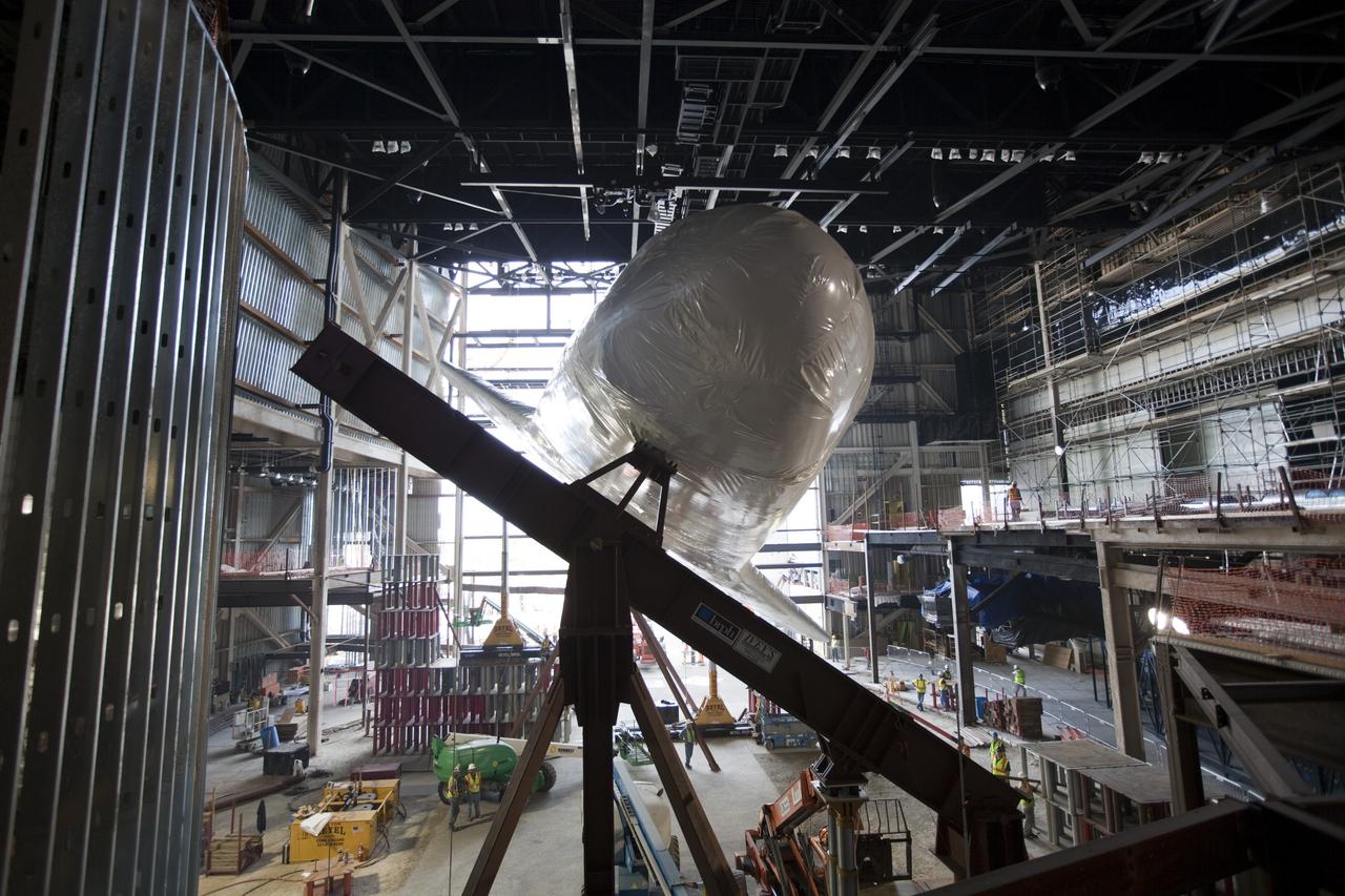 CAPE CANAVERAL, Fla. – The space shuttle Atlantis is lifted and tilted for display at the Kennedy Space Center Visitor Complex in Florida. Atlantis will be exhibited at 43.21 degrees with its payload bay doors open so the shuttle will look as it did in space. Atlantis was wrapped in a protective plastic to protect it from dust and debris while being prepared for display. The new home of Atlantis is scheduled to open in July 2013. The exhibits in the new, 90,000-square-foot interactive facility will tell the story of the 30-year Space Shuttle Program and what lies ahead in space exploration. More than 60 exhibits will be set up around Atlantis, including a full-scale mockup of the Hubble Space Telescope and a full-scale model of a portion of the International Space Station. Over the course of its 26-year career, Atlantis traveled 125,935,769 miles during 307 days in space over 33 missions. For more information, visit http://www.nasa.gov/transition Photo credit: NASA/ Dimitri Gerondidakis