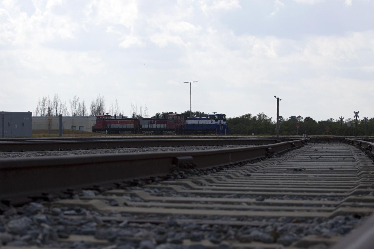 CAPE CANAVERAL, Fla. – Three NASA railroad locomotives at Kennedy Space Center in Florida move toward Launch Complex 39 area's Rotation, Processing and Surge Facility, or RPSF. The operation was to allow wheel and axle assemblies to be swapped between two of the locomotives. The RPSF was built to support work on the solid rocket used motors during the space shuttle era. The facility had never previously been used for another purpose, but is now free to serve other customers. With rails running into the building's high bay and a pair of heavy-lift cranes positioned overhead, the facility's capabilities were a perfect fit for the NASA Railroad's needs. Railroad managers wanted to trade the wheel and axle assemblies, or trucks, of locomotives No. 2 and No. 3. Locomotive No. 3 was painstakingly restored in recent years by the NASA Railroad team, and handles much of the rail work required at the center in the post-shuttle era. But the trucks on locomotive No. 2 are in better shape and are more environmentally friendly. For more information, visit: http://www.nasa.gov/exploration/systems/ground/rpsf_locomotives.html Photo credit: NASA/Jim Grossmann
