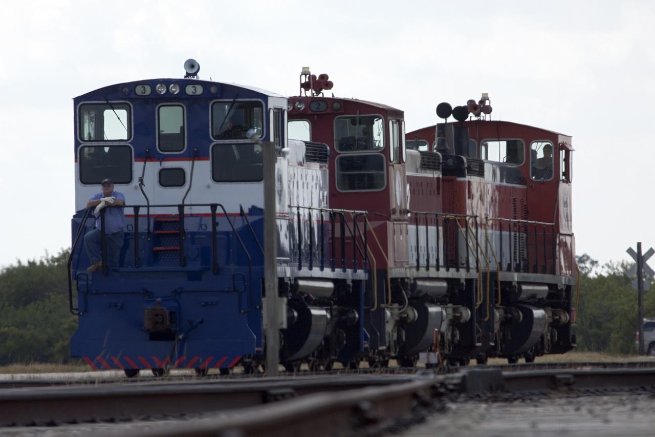 CAPE CANAVERAL, Fla. – Three NASA railroad locomotives at Kennedy Space Center in Florida move toward Launch Complex 39 area's Rotation, Processing and Surge Facility, or RPSF. The operation was to allow wheel and axle assemblies to be swapped between two of the locomotives. The RPSF was built to support work on the solid rocket used motors during the space shuttle era. The facility had never previously been used for another purpose, but is now free to serve other customers. With rails running into the building's high bay and a pair of heavy-lift cranes positioned overhead, the facility's capabilities were a perfect fit for the NASA Railroad's needs. Railroad managers wanted to trade the wheel and axle assemblies, or trucks, of locomotives No. 2 and No. 3. Locomotive No. 3 was painstakingly restored in recent years by the NASA Railroad team, and handles much of the rail work required at the center in the post-shuttle era. But the trucks on locomotive No. 2 are in better shape and are more environmentally friendly. For more information, visit: http://www.nasa.gov/exploration/systems/ground/rpsf_locomotives.html Photo credit: NASA/Jim Grossmann