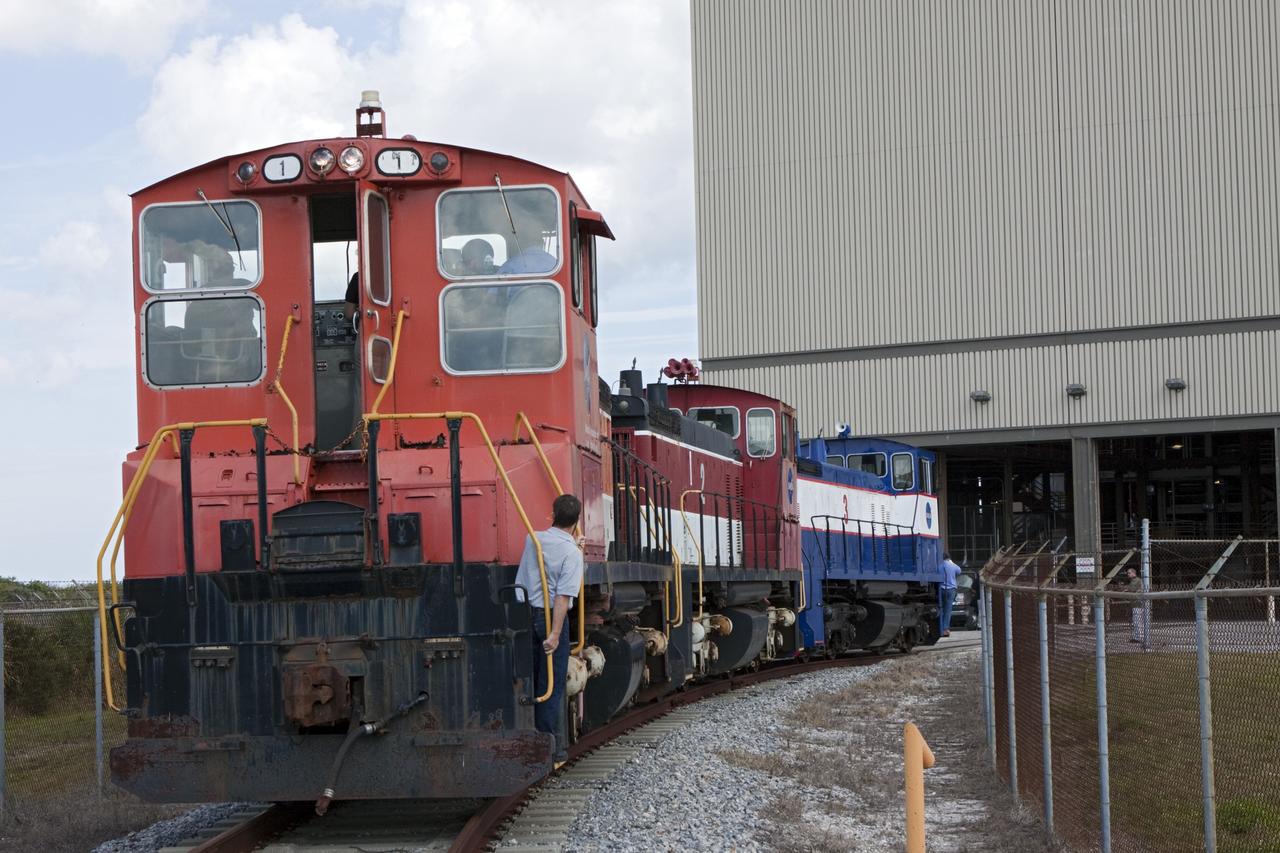 CAPE CANAVERAL, Fla. – Three NASA railroad locomotives at Kennedy Space Center in Florida move toward Launch Complex 39 area's Rotation, Processing and Surge Facility, or RPSF. The operation was to allow wheel and axle assemblies to be swapped between two of the locomotives. The RPSF was built to support work on the solid rocket used motors during the space shuttle era. The facility had never previously been used for another purpose, but is now free to serve other customers. With rails running into the building's high bay and a pair of heavy-lift cranes positioned overhead, the facility's capabilities were a perfect fit for the NASA Railroad's needs. Railroad managers wanted to trade the wheel and axle assemblies, or trucks, of locomotives No. 2 and No. 3. Locomotive No. 3 was painstakingly restored in recent years by the NASA Railroad team, and handles much of the rail work required at the center in the post-shuttle era. But the trucks on locomotive No. 2 are in better shape and are more environmentally friendly. For more information, visit: http://www.nasa.gov/exploration/systems/ground/rpsf_locomotives.html Photo credit: NASA/Jim Grossmann
