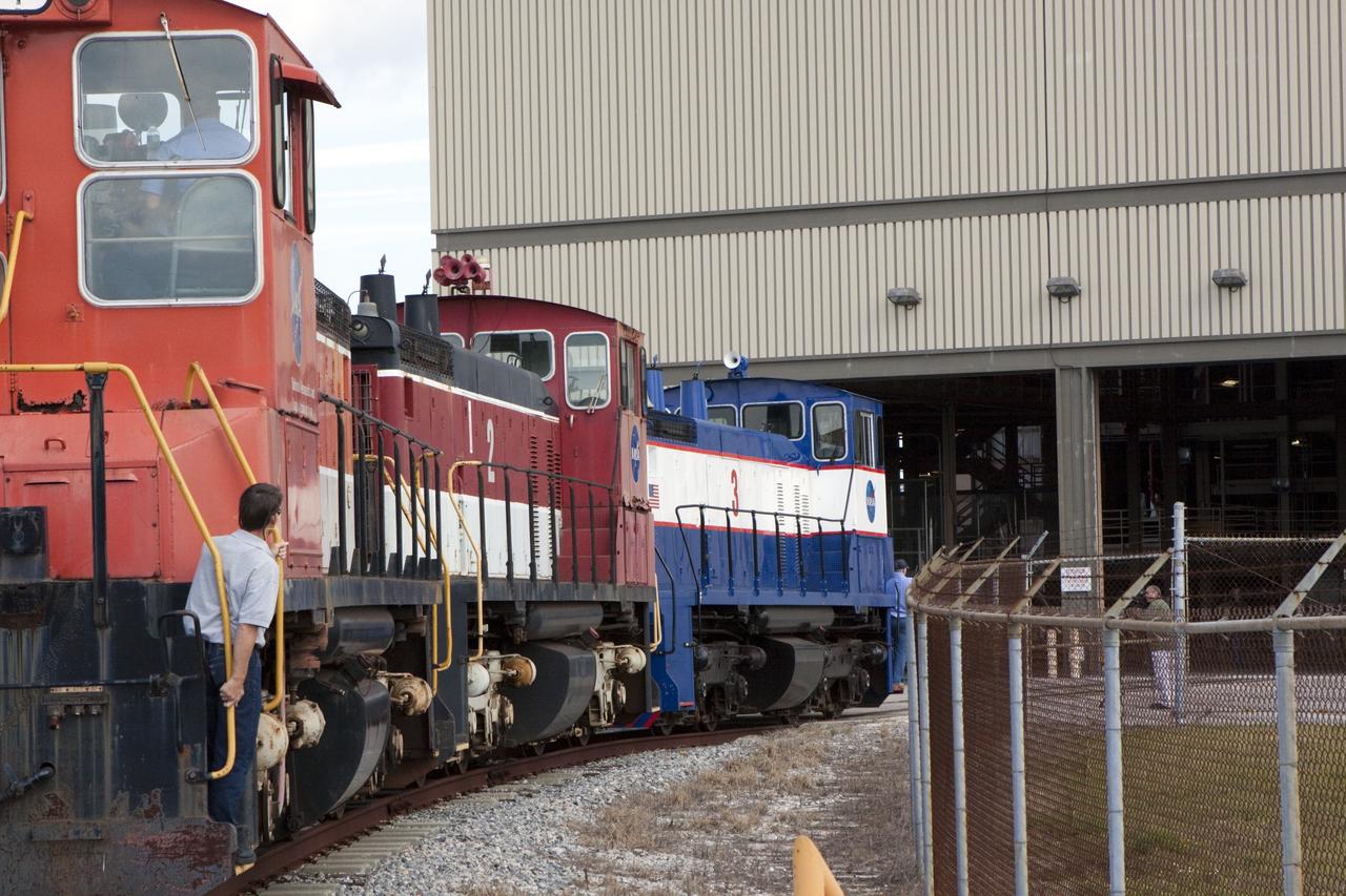 CAPE CANAVERAL, Fla. – Three NASA railroad locomotives at Kennedy Space Center in Florida move toward Launch Complex 39 area's Rotation, Processing and Surge Facility, or RPSF. The operation was to allow wheel and axle assemblies to be swapped between two of the locomotives. The RPSF was built to support work on the solid rocket used motors during the space shuttle era. The facility had never previously been used for another purpose, but is now free to serve other customers. With rails running into the building's high bay and a pair of heavy-lift cranes positioned overhead, the facility's capabilities were a perfect fit for the NASA Railroad's needs. Railroad managers wanted to trade the wheel and axle assemblies, or trucks, of locomotives No. 2 and No. 3. Locomotive No. 3 was painstakingly restored in recent years by the NASA Railroad team, and handles much of the rail work required at the center in the post-shuttle era. But the trucks on locomotive No. 2 are in better shape and are more environmentally friendly. For more information, visit: http://www.nasa.gov/exploration/systems/ground/rpsf_locomotives.html Photo credit: NASA/Jim Grossmann