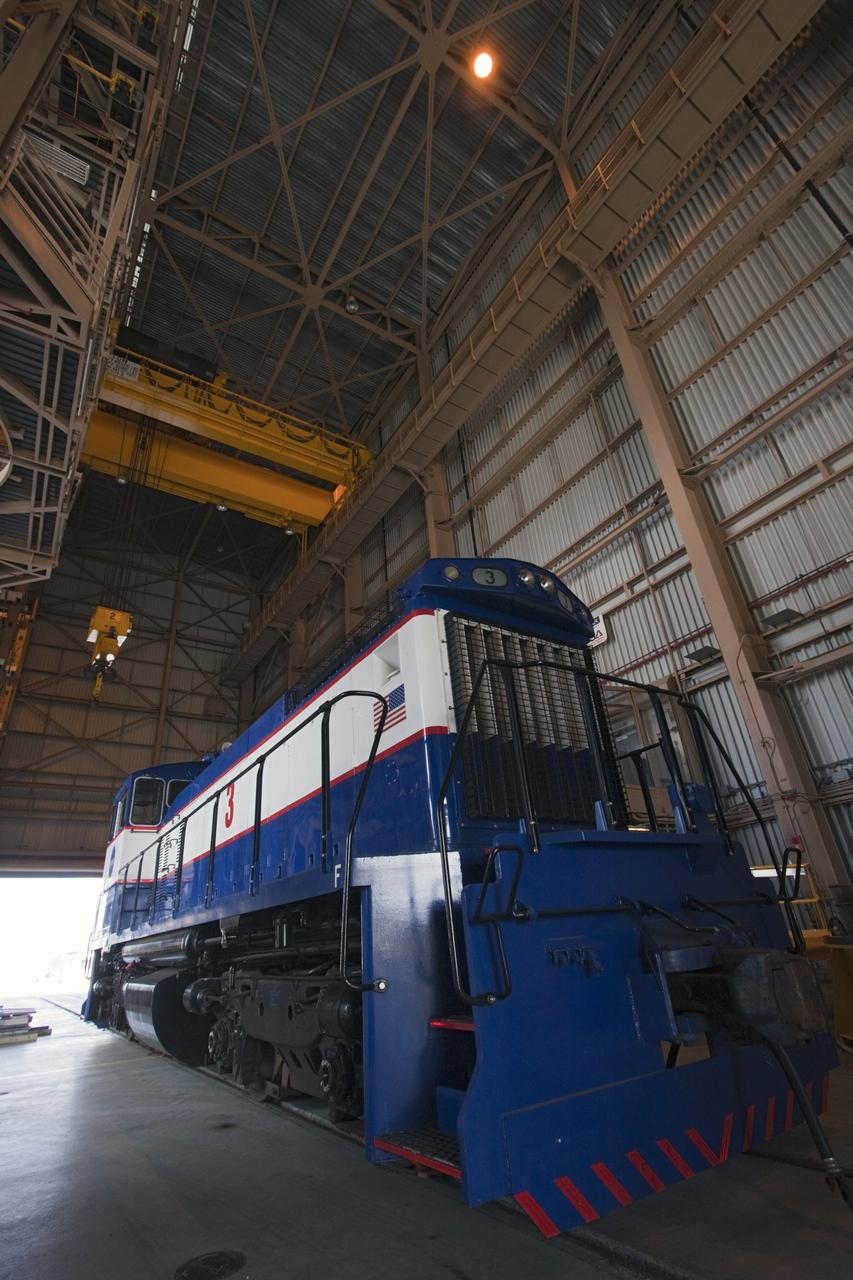 CAPE CANAVERAL, Fla. – A NASA railroad locomotive at Kennedy Space Center in Florida moves into Launch Complex 39 area's Rotation, Processing and Surge Facility, or RPSF. The operation was to allow wheel and axle assemblies to be swapped between two locomotives. The RPSF was built to support work on the solid rocket used motors during the space shuttle era. The facility had never previously been used for another purpose, but is now free to serve other customers. With rails running into the building's high bay and a pair of heavy-lift cranes positioned overhead, the facility's capabilities were a perfect fit for the NASA Railroad's needs. Railroad managers wanted to trade the wheel and axle assemblies, or trucks, of locomotives No. 2 and No. 3. Locomotive No. 3 was painstakingly restored in recent years by the NASA Railroad team, and handles much of the rail work required at the center in the post-shuttle era. But the trucks on locomotive No. 2 are in better shape and are more environmentally friendly. For more information, visit: http://www.nasa.gov/exploration/systems/ground/rpsf_locomotives.html Photo credit: NASA/Jim Grossmann