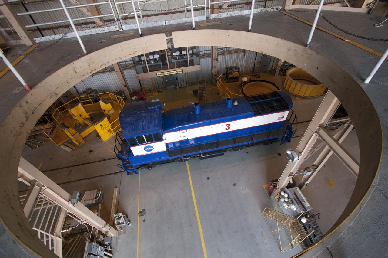 CAPE CANAVERAL, Fla. – A NASA railroad locomotive at Kennedy Space Center in Florida moves into Launch Complex 39 area's Rotation, Processing and Surge Facility, or RPSF. The operation was to allow wheel and axle assemblies to be swapped between two locomotives. The RPSF was built to support work on the solid rocket used motors during the space shuttle era. The facility had never previously been used for another purpose, but is now free to serve other customers. With rails running into the building's high bay and a pair of heavy-lift cranes positioned overhead, the facility's capabilities were a perfect fit for the NASA Railroad's needs. Railroad managers wanted to trade the wheel and axle assemblies, or trucks, of locomotives No. 2 and No. 3. Locomotive No. 3 was painstakingly restored in recent years by the NASA Railroad team, and handles much of the rail work required at the center in the post-shuttle era. But the trucks on locomotive No. 2 are in better shape and are more environmentally friendly. For more information, visit: http://www.nasa.gov/exploration/systems/ground/rpsf_locomotives.html Photo credit: NASA/Jim Grossmann