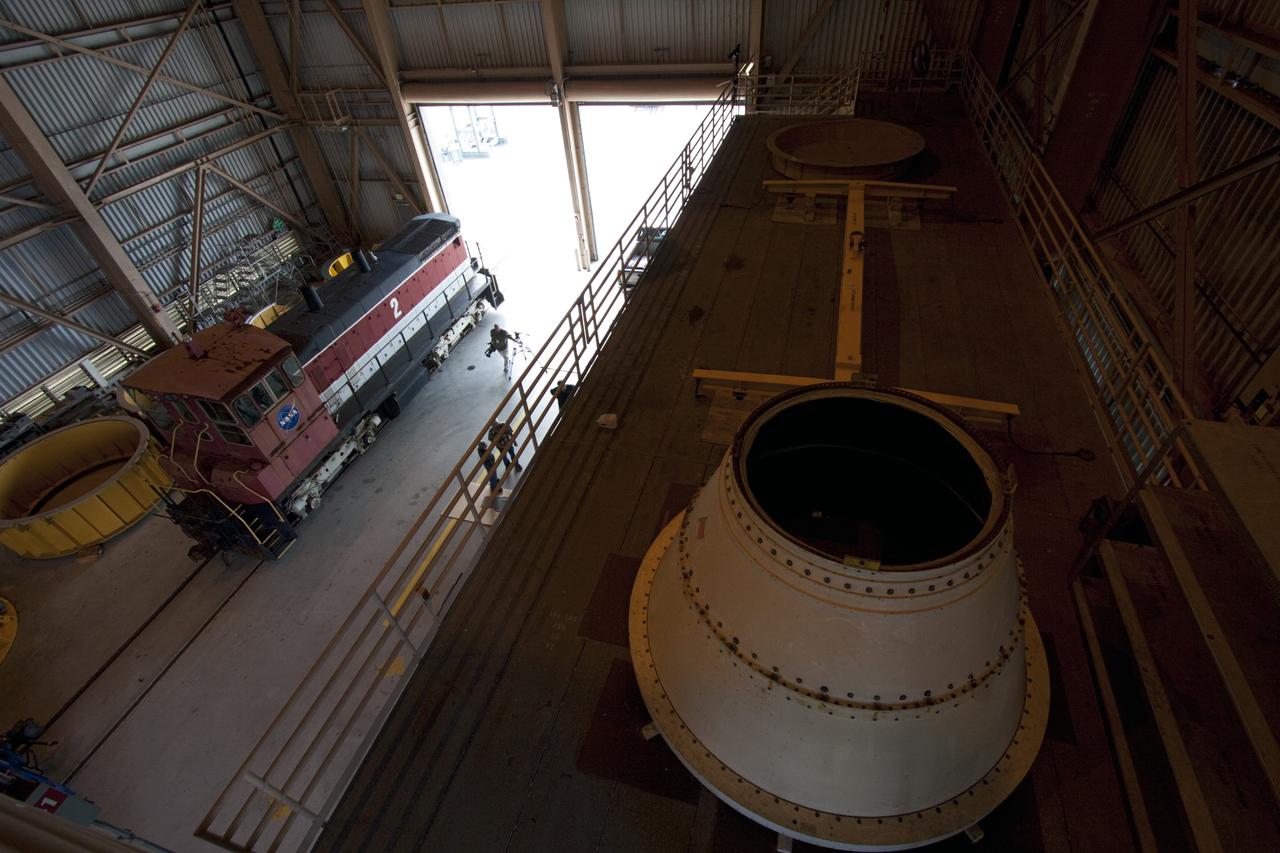 CAPE CANAVERAL, Fla. – A NASA railroad locomotive at Kennedy Space Center in Florida moves into Launch Complex 39 area's Rotation, Processing and Surge Facility, or RPSF. The operation was to allow wheel and axle assemblies to be swapped between two locomotives. The RPSF was built to support work on the solid rocket used motors during the space shuttle era. The facility had never previously been used for another purpose, but is now free to serve other customers. With rails running into the building's high bay and a pair of heavy-lift cranes positioned overhead, the facility's capabilities were a perfect fit for the NASA Railroad's needs. Railroad managers wanted to trade the wheel and axle assemblies, or trucks, of locomotives No. 2 and No. 3. Locomotive No. 3 was painstakingly restored in recent years by the NASA Railroad team, and handles much of the rail work required at the center in the post-shuttle era. But the trucks on locomotive No. 2 are in better shape and are more environmentally friendly. For more information, visit: http://www.nasa.gov/exploration/systems/ground/rpsf_locomotives.html Photo credit: NASA/Jim Grossmann