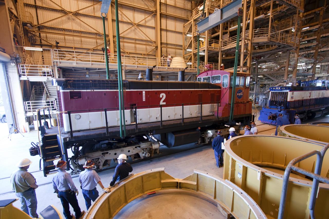 CAPE CANAVERAL, Fla. – Inside the Rotation, Processing and Surge Facility, or RPSF, at the Kennedy Space Center in Florida, an overhead crane lifts NASA locomotive No. 2 off of its trucks to be moved aside, clearing the way for locomotive No. 3 to be raised off its trucks and moved into position atop the trucks previously used by locomotive No. 2. The RPSF was built to support work on the solid rocket used motors during the space shuttle era. The facility had never previously been used for another purpose, but is now free to serve other customers. With rails running into the building's high bay and a pair of heavy-lift cranes positioned overhead, the facility's capabilities were a perfect fit for the NASA Railroad's needs. Railroad managers wanted to trade the wheel and axle assemblies, or trucks, of locomotives No. 2 and No. 3. Locomotive No. 3 was painstakingly restored in recent years by the NASA Railroad team, and handles much of the rail work required at the center in the post-shuttle era. But the trucks on locomotive No. 2 are in better shape and are more environmentally friendly. For more information, visit: http://www.nasa.gov/exploration/systems/ground/rpsf_locomotives.html Photo credit: NASA/Jim Grossmann