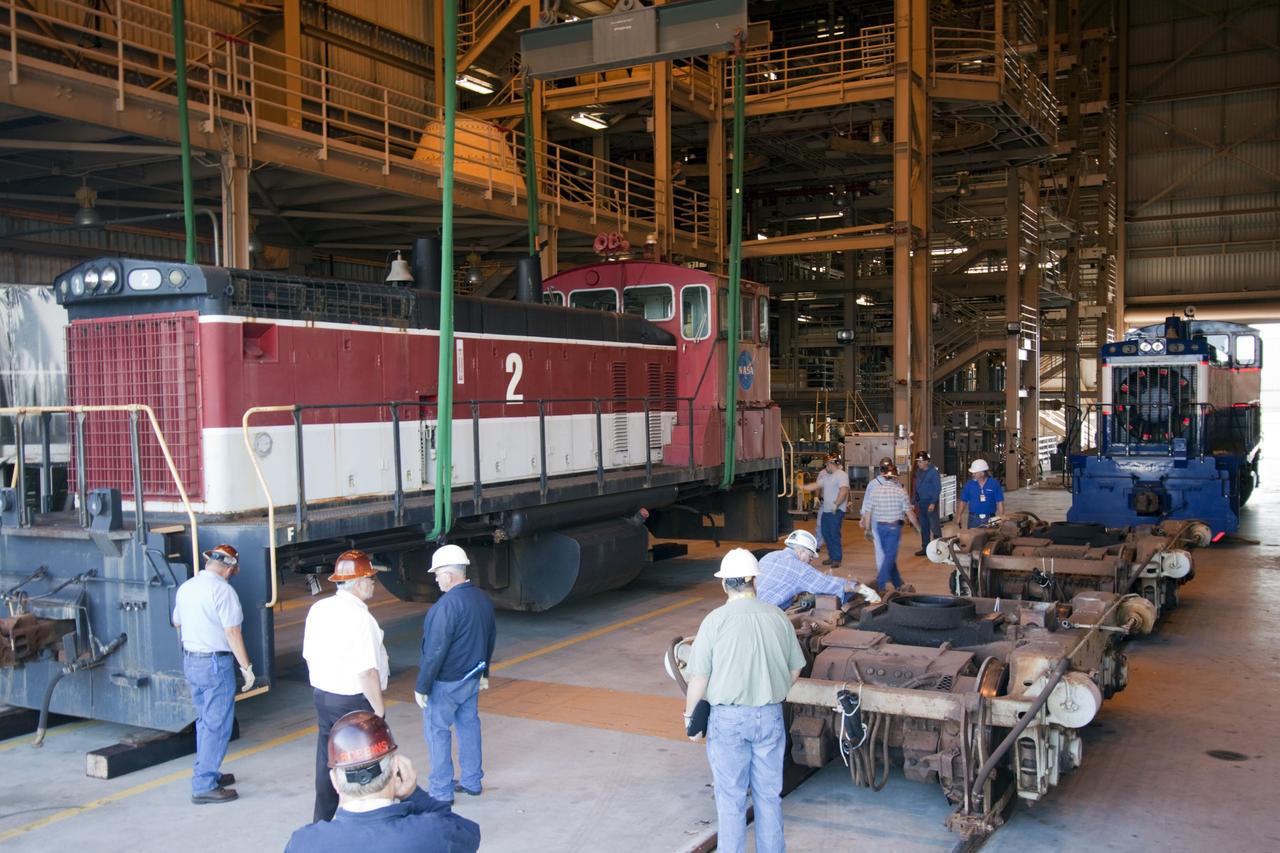 CAPE CANAVERAL, Fla. – Inside the Rotation, Processing and Surge Facility, or RPSF, at the Kennedy Space Center in Florida, an overhead crane moves NASA locomotive No. 2 aside after being lifted off of its trucks, clearing the way for locomotive No. 3 to be raised off its trucks and moved into position atop the trucks previously used by locomotive No. 2. The RPSF was built to support work on the solid rocket used motors during the space shuttle era. The facility had never previously been used for another purpose, but is now free to serve other customers. With rails running into the building's high bay and a pair of heavy-lift cranes positioned overhead, the facility's capabilities were a perfect fit for the NASA Railroad's needs. Railroad managers wanted to trade the wheel and axle assemblies, or trucks, of locomotives No. 2 and No. 3. Locomotive No. 3 was painstakingly restored in recent years by the NASA Railroad team, and handles much of the rail work required at the center in the post-shuttle era. But the trucks on locomotive No. 2 are in better shape and are more environmentally friendly. For more information, visit: http://www.nasa.gov/exploration/systems/ground/rpsf_locomotives.html Photo credit: NASA/Jim Grossmann