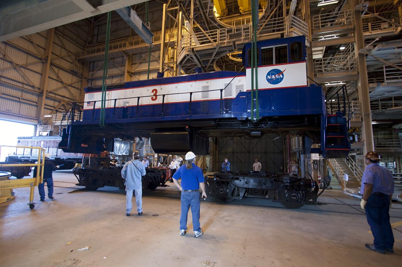 CAPE CANAVERAL, Fla. – Inside the Rotation, Processing and Surge Facility, or RPSF, at the Kennedy Space Center in Florida, an overhead crane lifts NASA locomotive No. 3 off of its trucks to be moved into position atop the trucks previously used by locomotive No. 2. The RPSF was built to support work on the solid rocket used motors during the space shuttle era. The facility had never previously been used for another purpose, but is now free to serve other customers. With rails running into the building's high bay and a pair of heavy-lift cranes positioned overhead, the facility's capabilities were a perfect fit for the NASA Railroad's needs. Railroad managers wanted to trade the wheel and axle assemblies, or trucks, of locomotives No. 2 and No. 3. Locomotive No. 3 was painstakingly restored in recent years by the NASA Railroad team, and handles much of the rail work required at the center in the post-shuttle era. But the trucks on locomotive No. 2 are in better shape and are more environmentally friendly. For more information, visit: http://www.nasa.gov/exploration/systems/ground/rpsf_locomotives.html Photo credit: NASA/Jim Grossmann