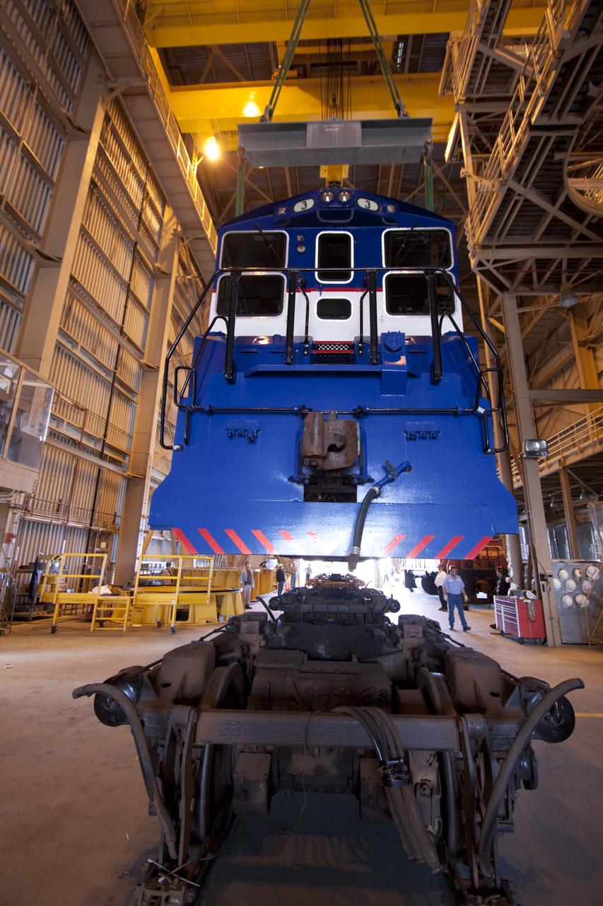 CAPE CANAVERAL, Fla. – Inside the Rotation, Processing and Surge Facility, or RPSF, at the Kennedy Space Center in Florida, an overhead crane lifts NASA locomotive No. 3 off of its trucks to be moved into position atop the trucks previously used by locomotive No. 2. The RPSF was built to support work on the solid rocket used motors during the space shuttle era. The facility had never previously been used for another purpose, but is now free to serve other customers. With rails running into the building's high bay and a pair of heavy-lift cranes positioned overhead, the facility's capabilities were a perfect fit for the NASA Railroad's needs. Railroad managers wanted to trade the wheel and axle assemblies, or trucks, of locomotives No. 2 and No. 3. Locomotive No. 3 was painstakingly restored in recent years by the NASA Railroad team, and handles much of the rail work required at the center in the post-shuttle era. But the trucks on locomotive No. 2 are in better shape and are more environmentally friendly. For more information, visit: http://www.nasa.gov/exploration/systems/ground/rpsf_locomotives.html Photo credit: NASA/Jim Grossmann